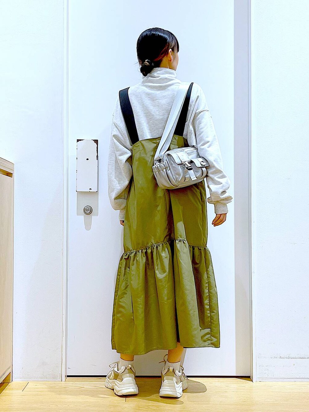 ベージュ系のスウェット、ベージュ系のスニーカー、シルバー系のショルダーバッグを着用したレディースの春コーディネートの5枚目の写真