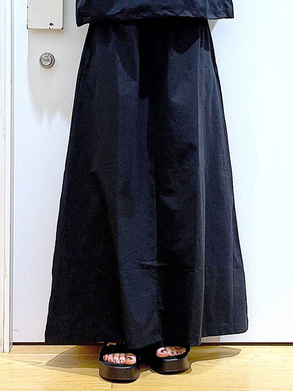 ブラック系のサンダル、ブラック系のTシャツ/カットソー、ブラック系のスカートを着用したレディースの夏コーディネートの8枚目の写真