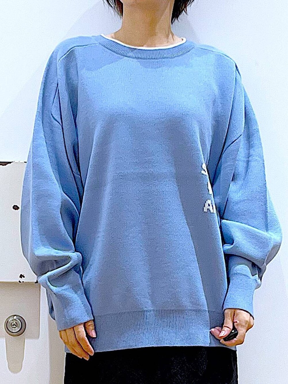 ブルー系のニット/セーター、ホワイト系のショルダーバッグ、ベージュ系のブーツを着用したレディースの冬コーディネートの7枚目の写真