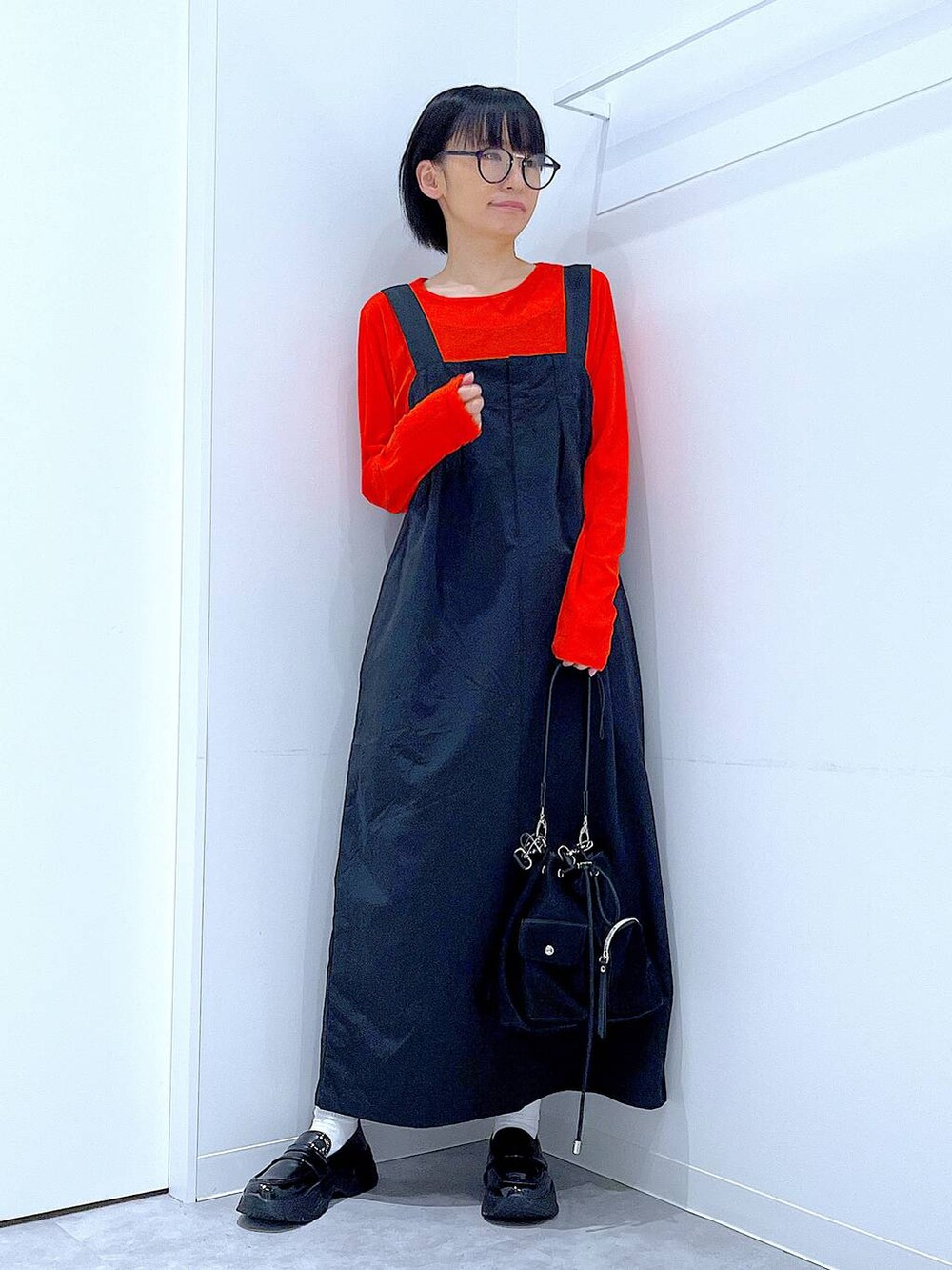 オレンジ系のTシャツ/カットソー、ブラック系のローファー、ブラック系のショルダーバッグを着用したレディースの秋コーディネートの2枚目の写真