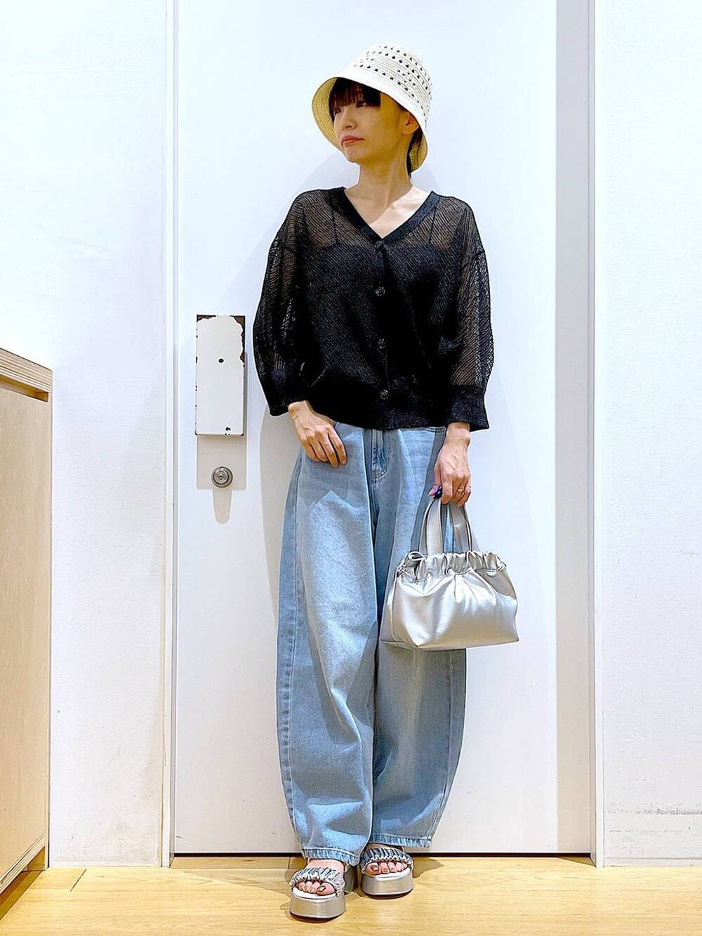 ブルー系のデニムパンツ、シルバー系のショルダーバッグ、シルバー系のサンダルを着用したレディースの夏コーディネートの2枚目の写真