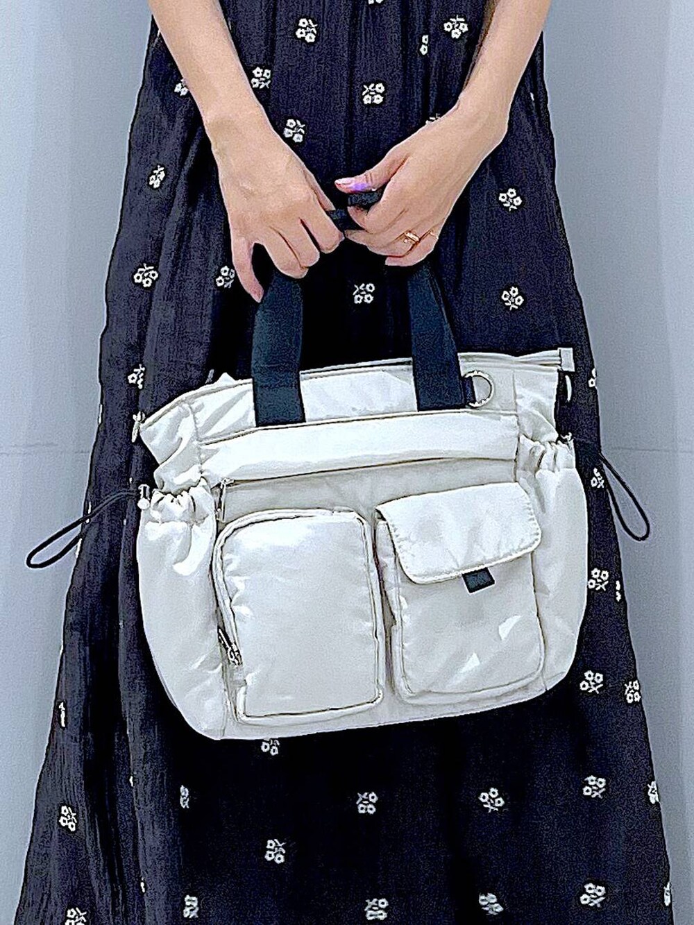 ブラック系のワンピース、ホワイト系のトートバッグ、ホワイト系のバレッタ/ヘアクリップを着用したレディースの夏コーディネートの9枚目の写真