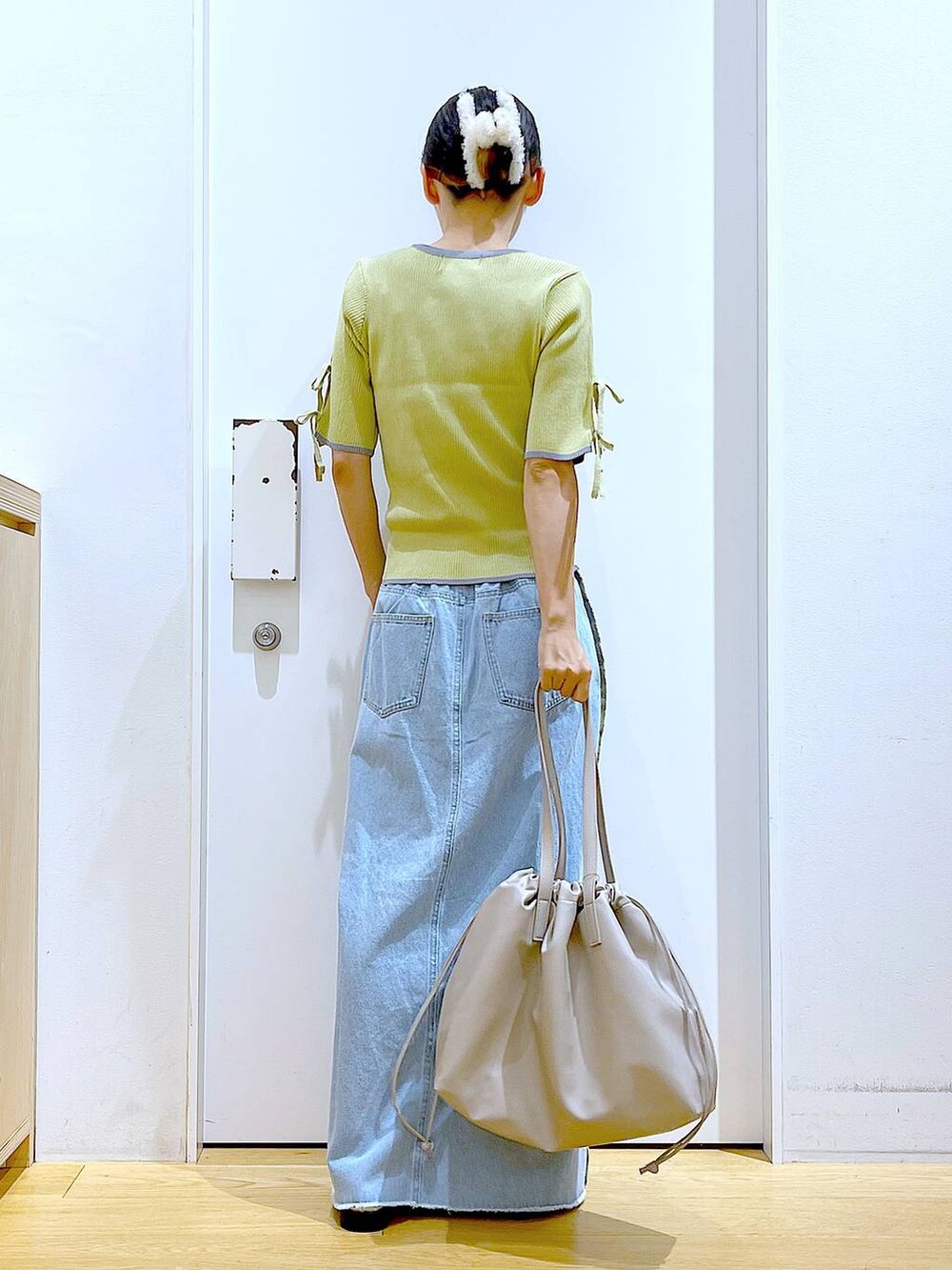 ベージュ系のトートバッグ、シルバー系のローファー、イエロー系のニット/セーターを着用したレディースの秋コーディネートの5枚目の写真