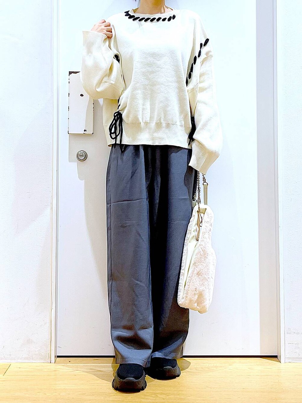 ホワイト系のショルダーバッグ、ブラック系のブーツ、グレー系のその他パンツを着用したレディースの冬コーディネートの6枚目の写真