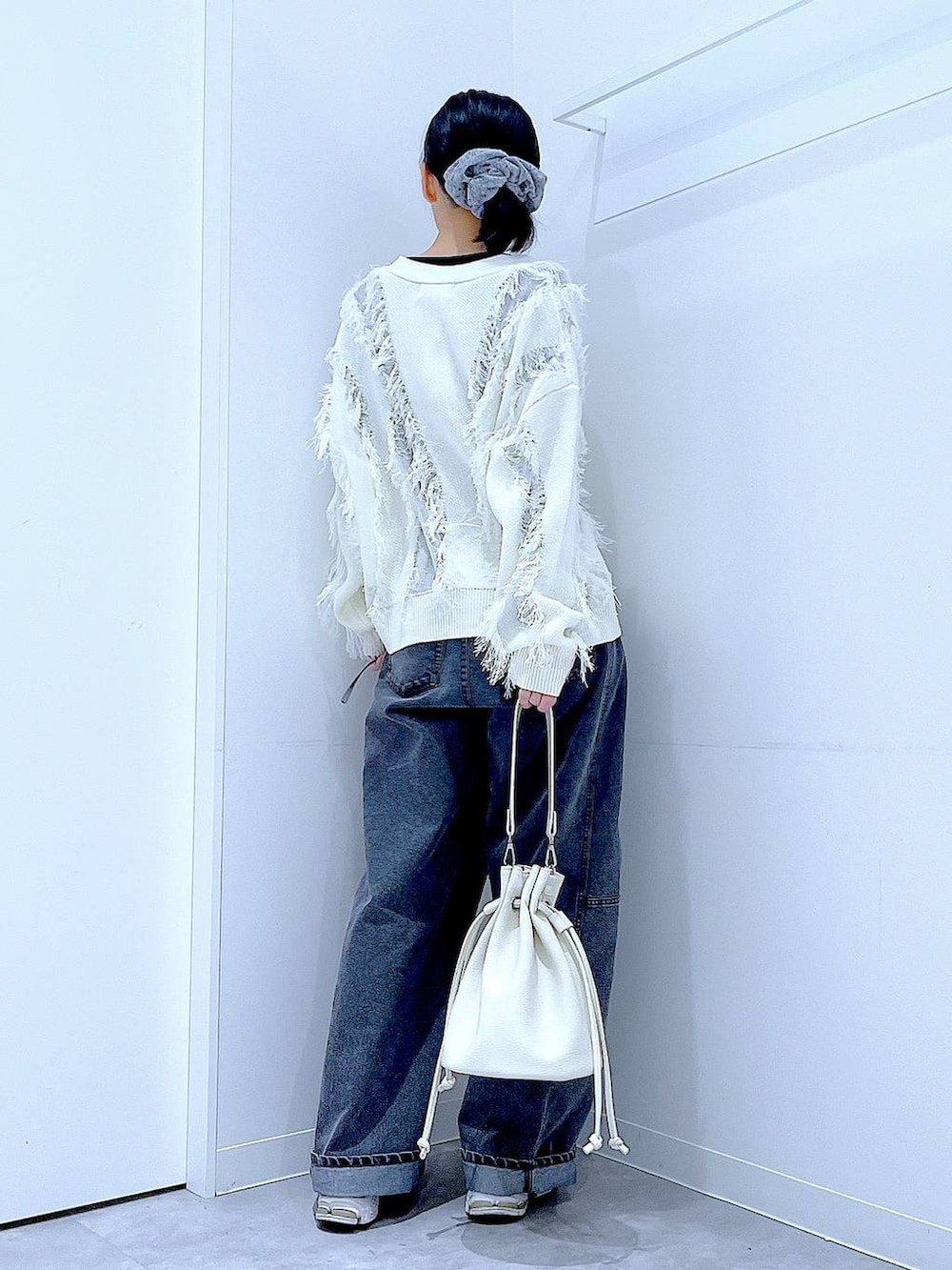 ブラック系のTシャツ/カットソー、ブラック系のデニムパンツ、ホワイト系のショルダーバッグを着用したレディースの春コーディネートの5枚目の写真