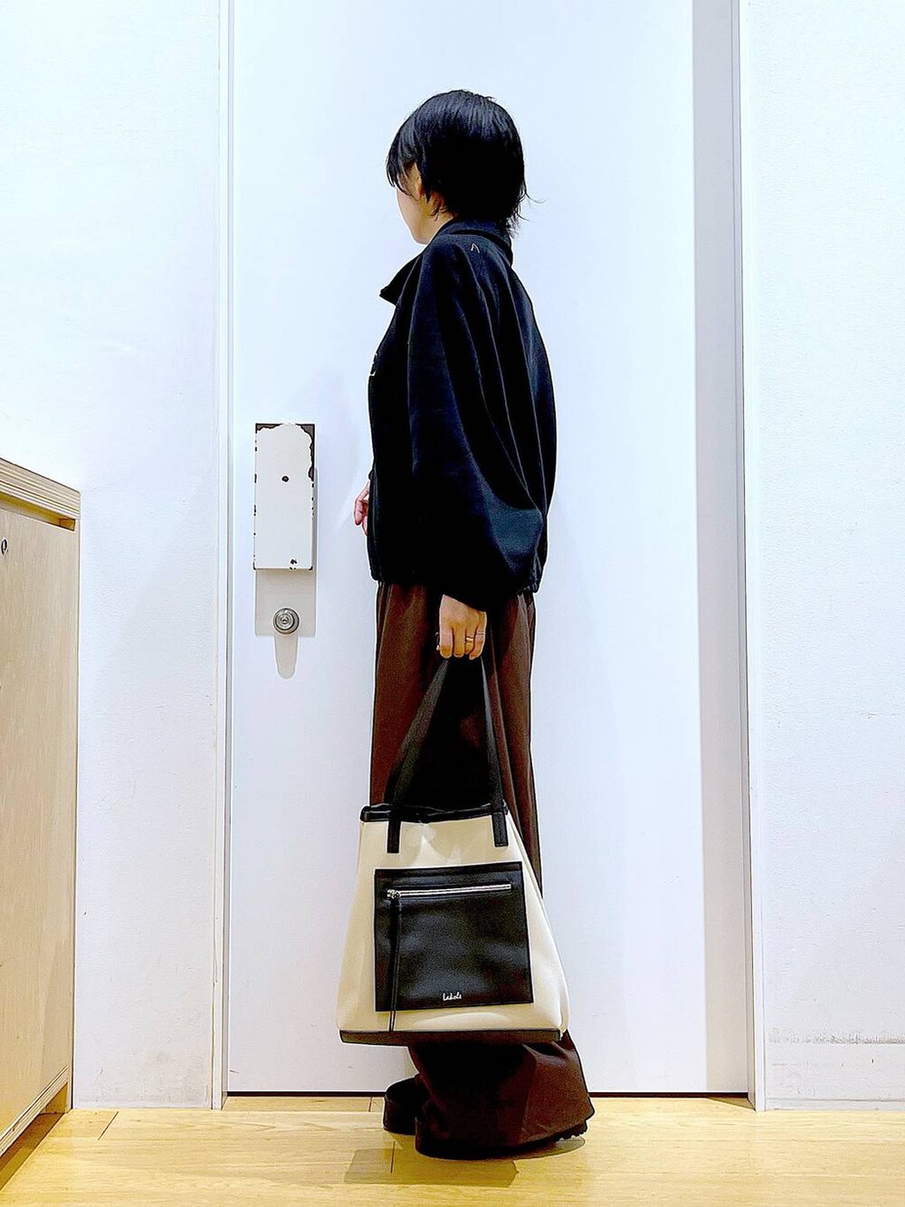 ブラック系のスリッポン、ブラウン系のその他パンツ、ホワイト系のトートバッグを着用したレディースの秋コーディネートの3枚目の写真