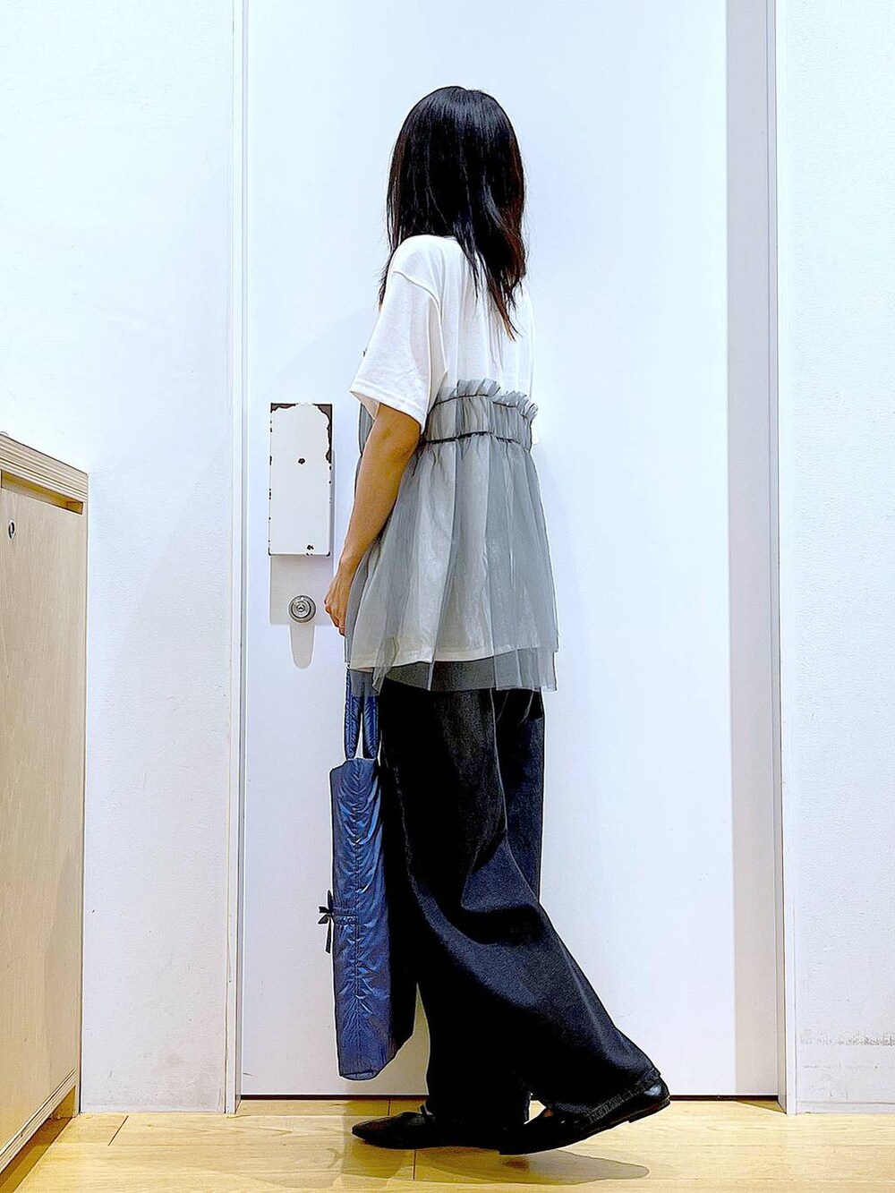 グレー系のTシャツ/カットソー、ブラック系のデニムパンツ、ブルー系のトートバッグを着用したレディースの秋コーディネートの3枚目の写真