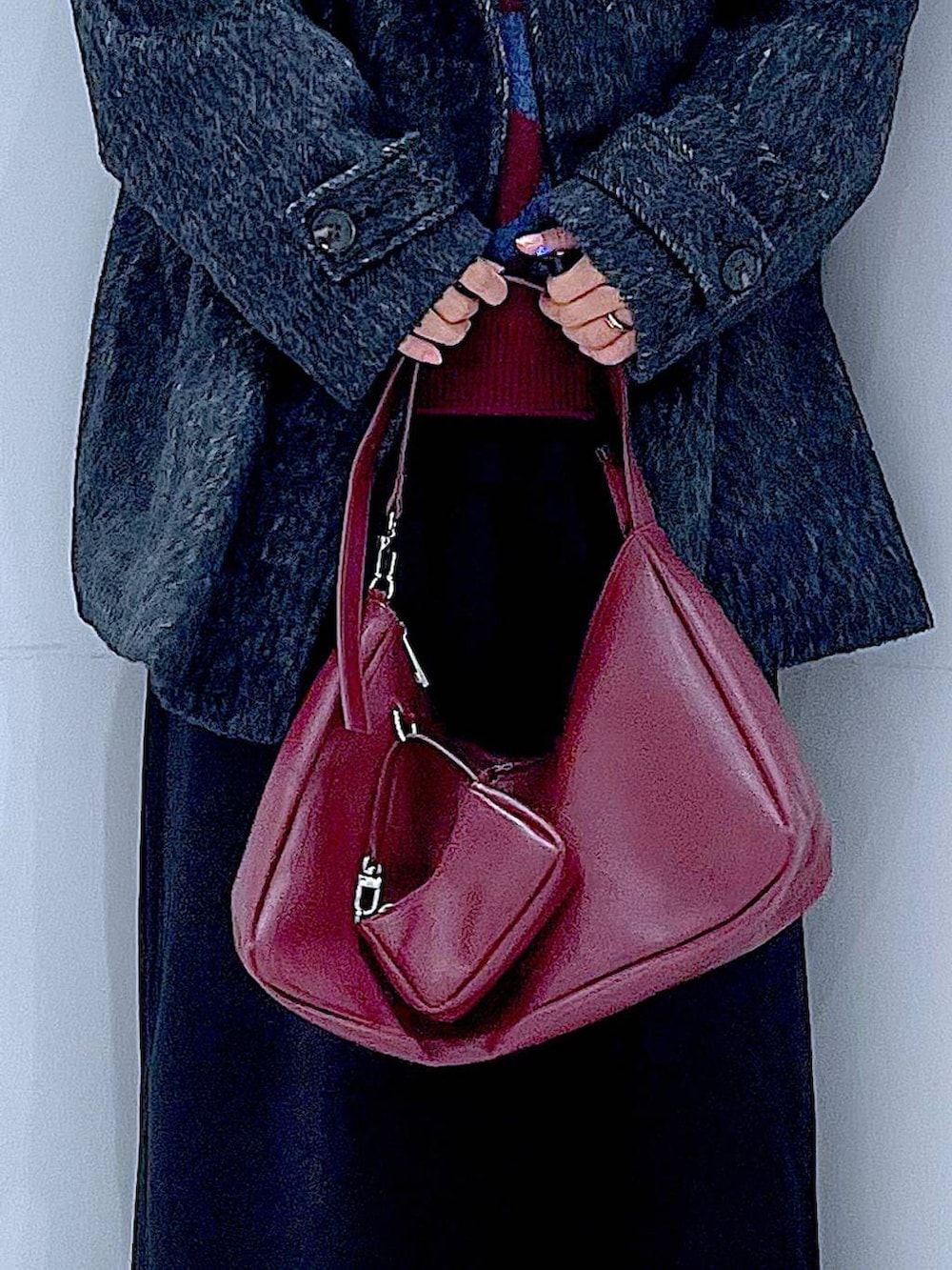 ブラック系のスカート、ブラック系のステンカラーコート、ブラック系のブーツを着用したレディースの冬コーディネートの9枚目の写真