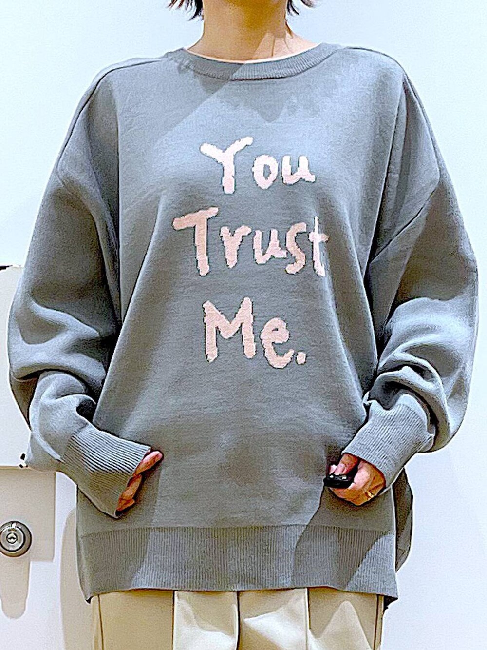 グレー系のニット/セーター、ブラック系のトートバッグ、ベージュ系のブーツを着用したレディースの冬コーディネートの7枚目の写真