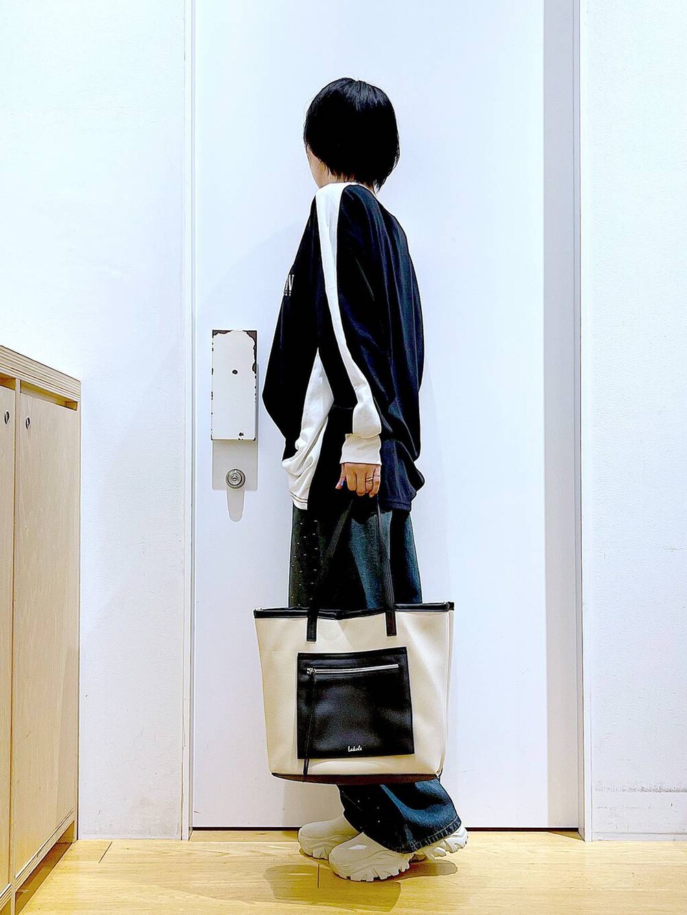 ベージュ系のブーツ、ホワイト系のトートバッグ、ブラック系のTシャツ/カットソーを着用したレディースの秋コーディネートの3枚目の写真