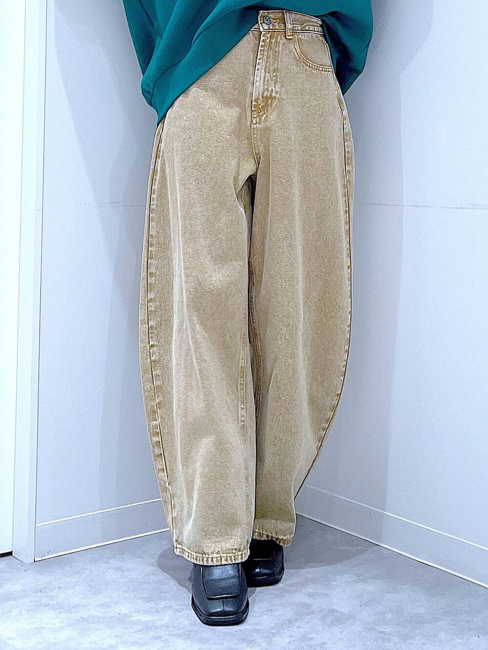 ベージュ系のデニムパンツ、ブラック系のショルダーバッグ、ブラック系のブーツを着用したレディースの冬コーディネートの8枚目の写真