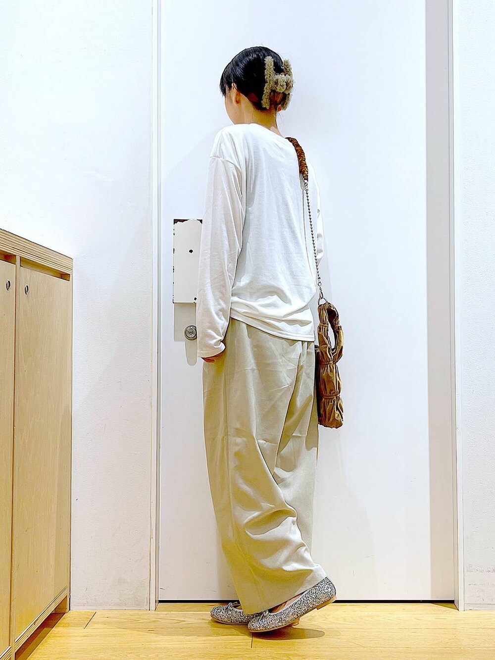 シルバー系のパンプス、イエロー系のショルダーバッグ、ベージュ系のその他パンツを着用したレディースの秋コーディネートの3枚目の写真