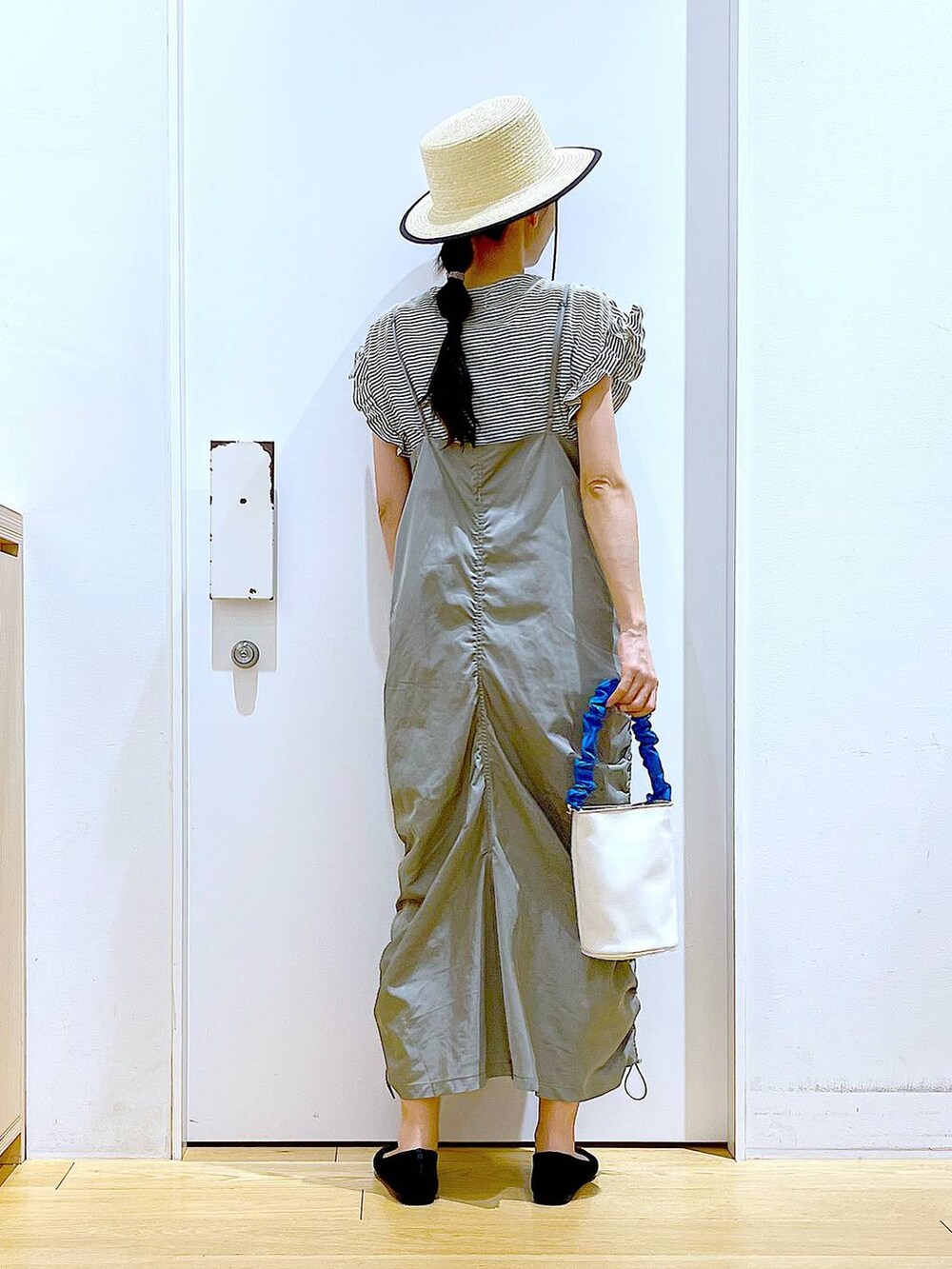 ブルー系のショルダーバッグ、ブラック系のパンプス、グリーン系のワンピースを着用したレディースの春コーディネートの5枚目の写真