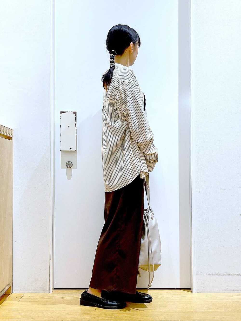 ベージュ系のトートバッグ、ブラック系のローファー、ブラウン系のその他パンツを着用したレディースの秋コーディネートの4枚目の写真