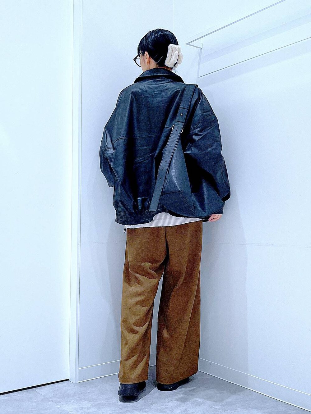 ブラック系のブルゾン、ブラック系のブーツ、ベージュ系のニット/セーターを着用したレディースの秋コーディネートの5枚目の写真