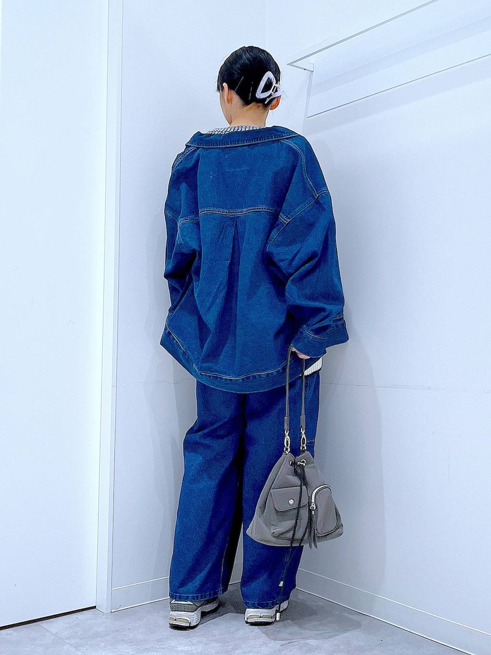 ブルー系のデニムジャケット、ホワイト系のニット/セーター、ブルー系のデニムパンツを着用したレディースの冬コーディネートの5枚目の写真