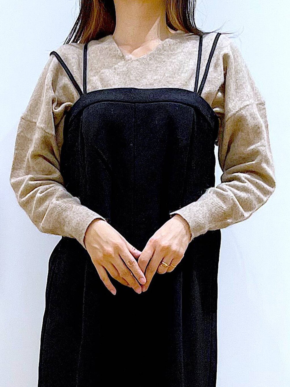 ベージュ系のニット/セーター、ブラック系のブーツ、ブラウン系のクラッチバッグを着用したレディースの冬コーディネートの7枚目の写真