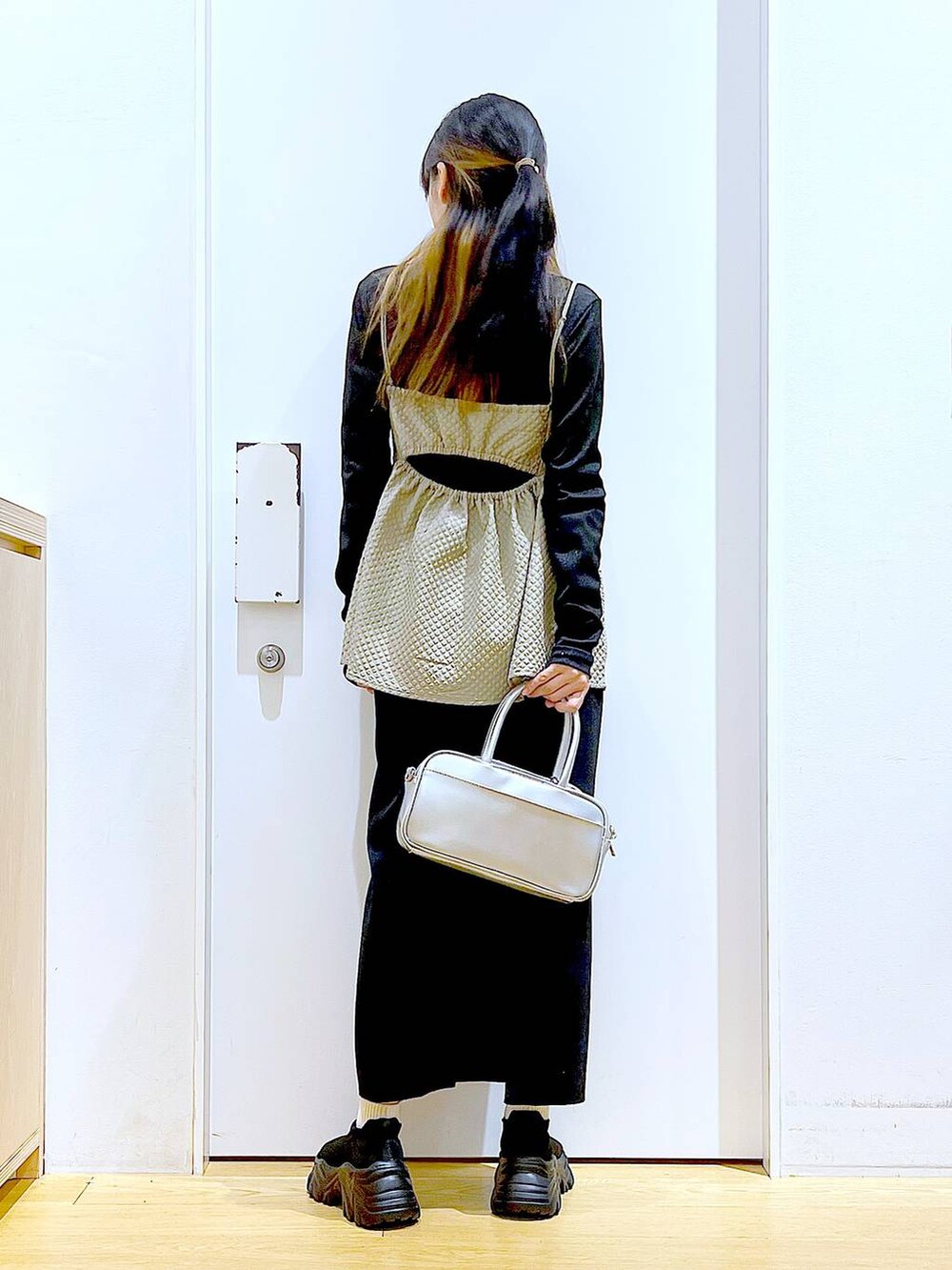 シルバー系のショルダーバッグ、ブラック系のTシャツ/カットソー、ブラック系のスニーカーを着用したレディースの春コーディネートの5枚目の写真