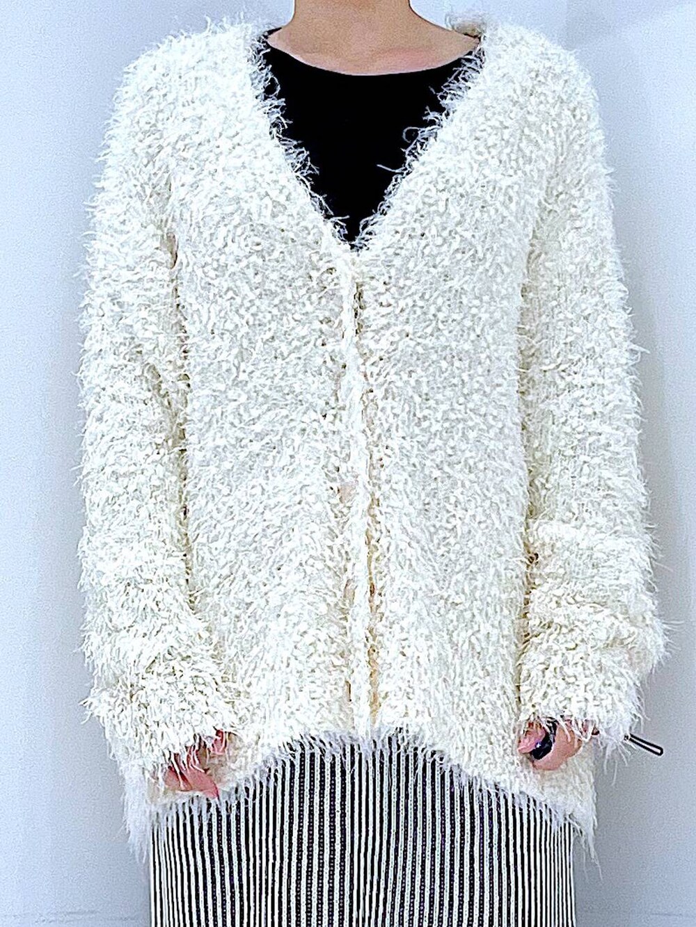 ブラック系のブーツ、ベージュ系のスカート、ベージュ系のカーディガン/ボレロを着用したレディースの秋コーディネートの7枚目の写真