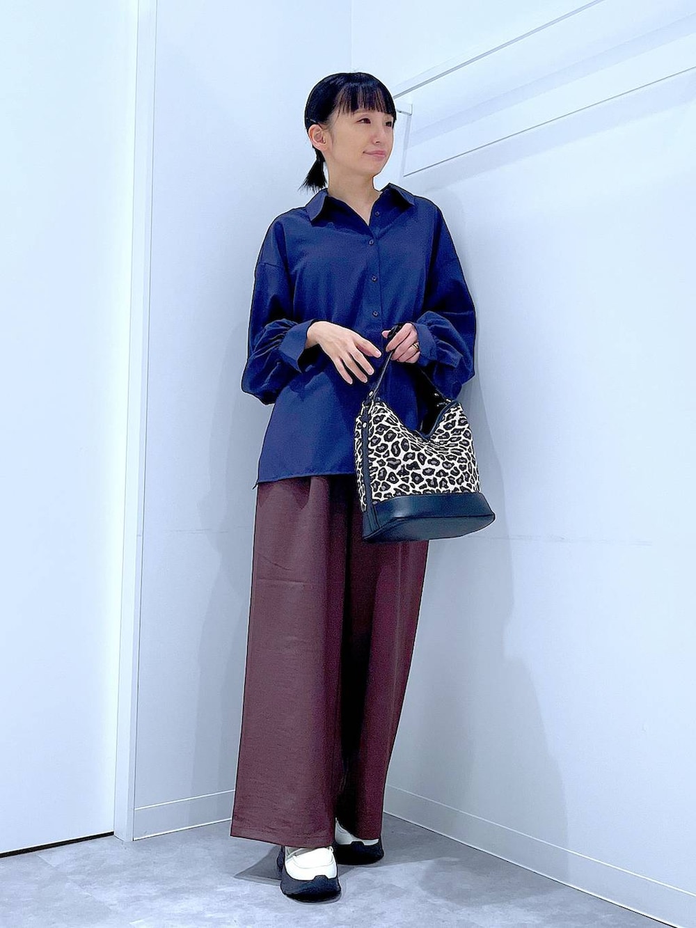 ブラウン系のその他パンツ、ホワイト系のローファー、その他のショルダーバッグを着用したレディースの秋コーディネートの2枚目の写真