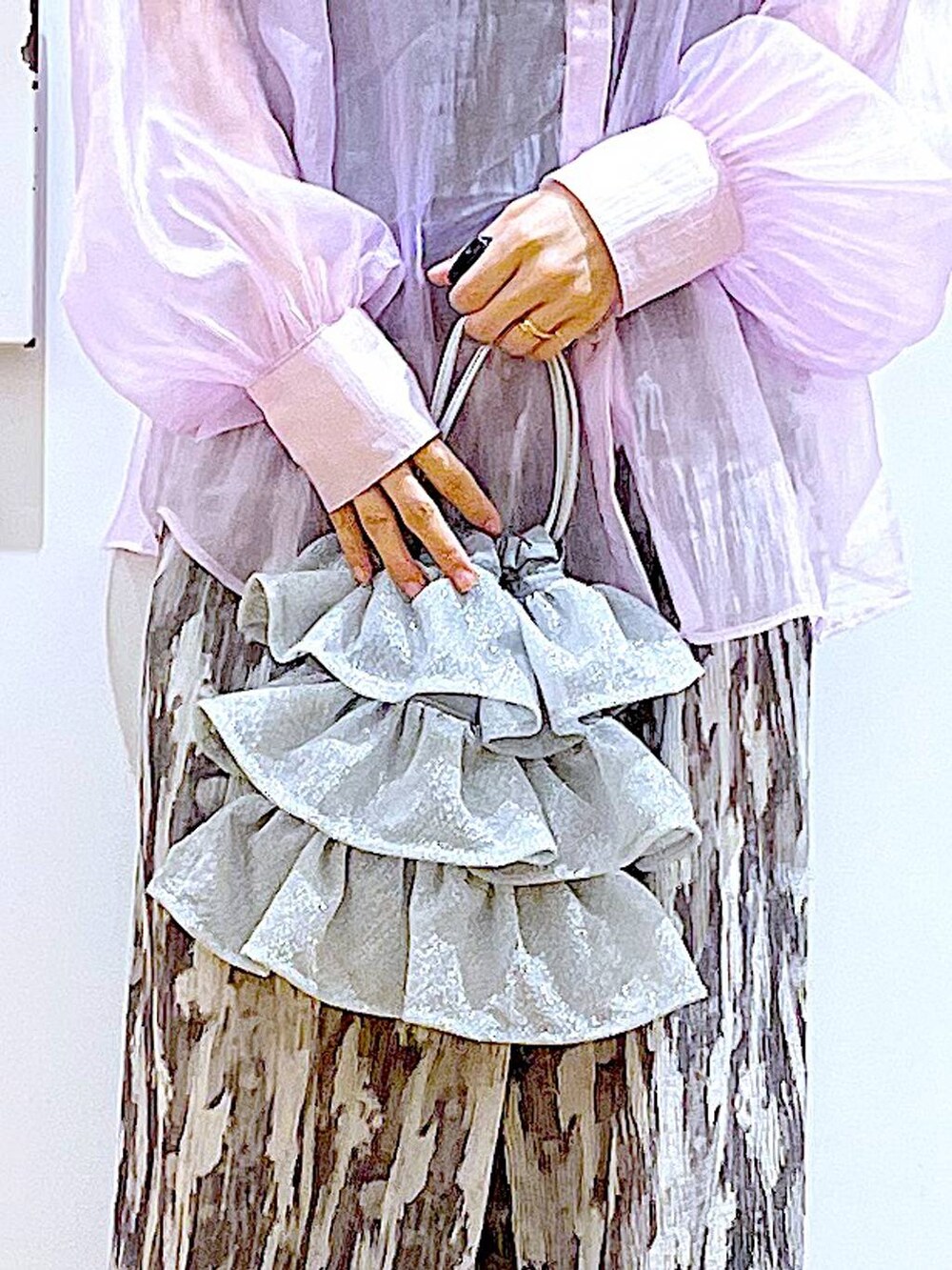 シルバー系のショルダーバッグ、パープル系のシャツ/ブラウス、ブラック系のサンダルを着用したレディースの夏コーディネートの9枚目の写真