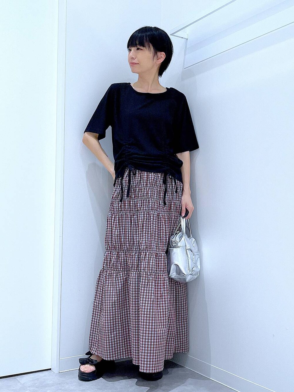 ブラック系のサンダル、ブラック系のTシャツ/カットソー、その他のショルダーバッグを着用したレディースの夏コーディネートの2枚目の写真