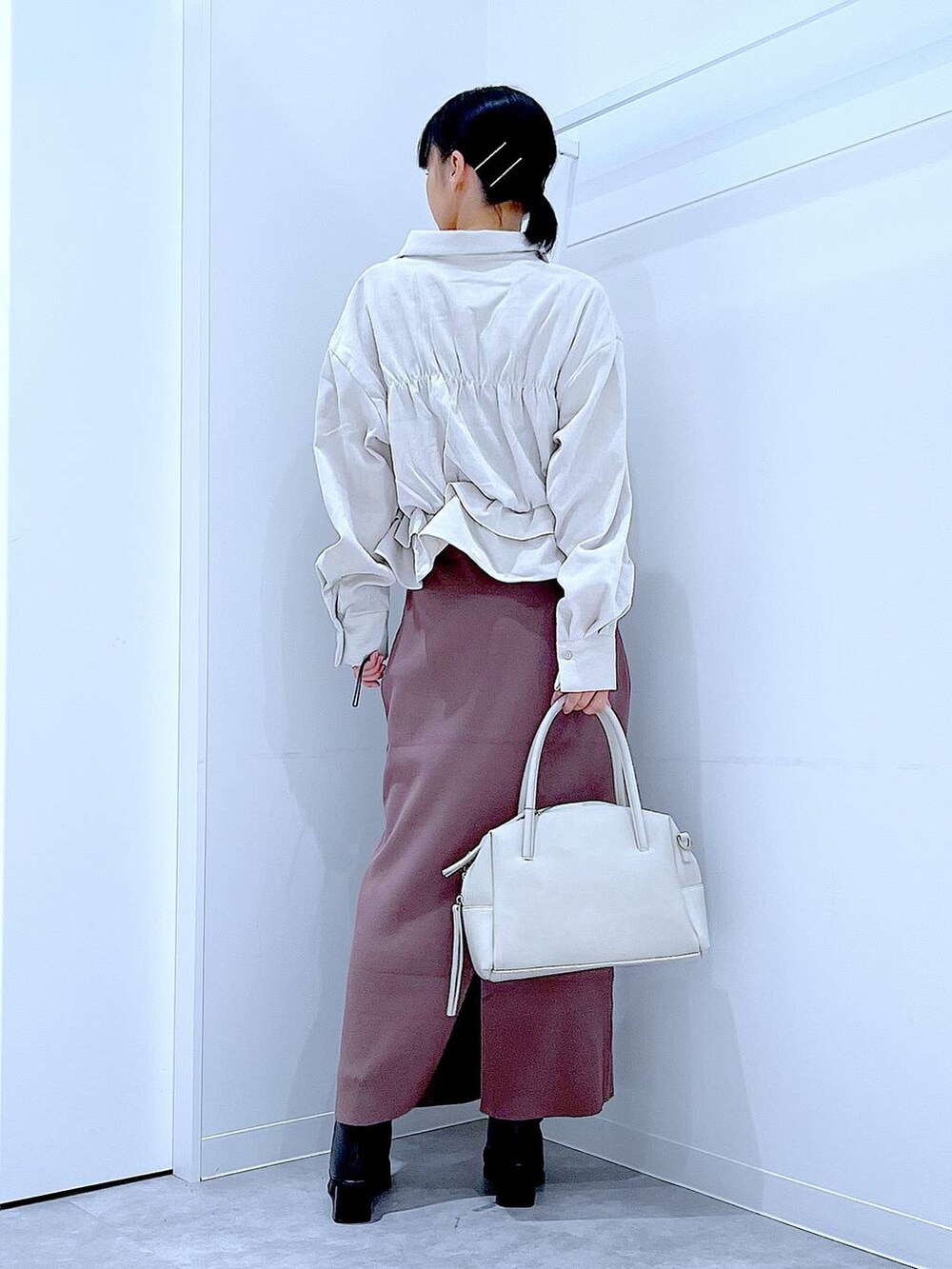 グレー系のボストンバッグ、ブラック系のブーツ、ベージュ系のシャツ/ブラウスを着用したレディースの秋コーディネートの5枚目の写真