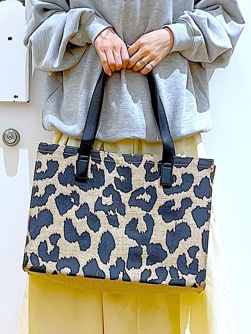 グレー系のスウェット、ベージュ系のスニーカー、イエロー系のスカートを着用したレディースの春コーディネートの9枚目の写真