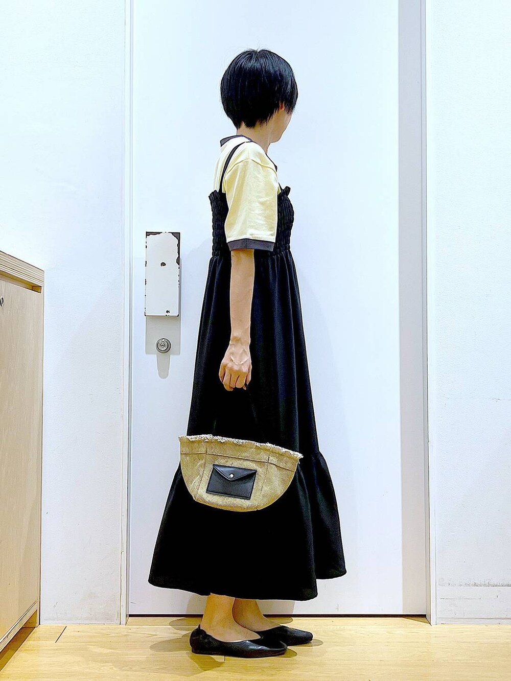 ブラック系のパンプス、ベージュ系のショルダーバッグ、ブラック系のワンピースを着用したレディースの夏コーディネートの4枚目の写真