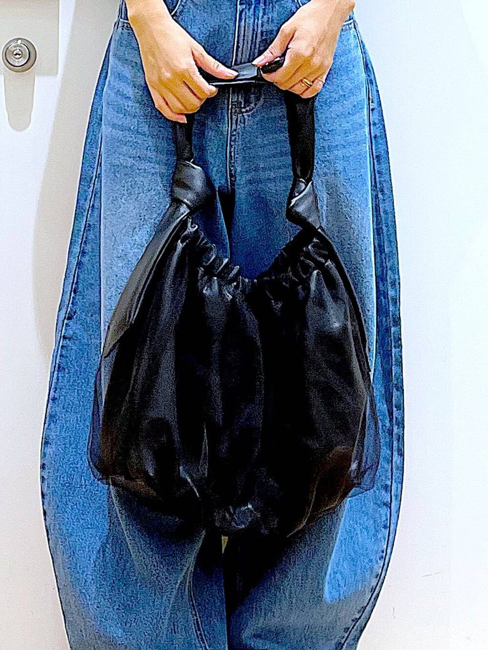 ブラック系のトートバッグ、ブルー系のデニムパンツ、その他のカーディガン/ボレロを着用したレディースの秋コーディネートの9枚目の写真