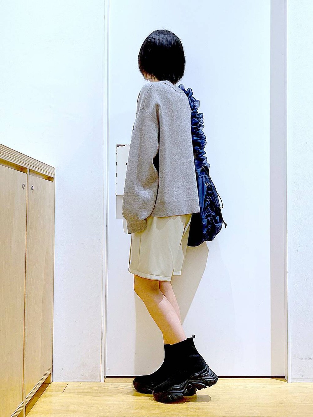 ブルー系のショルダーバッグ、ブラック系のブーツ、ベージュ系のその他パンツを着用したレディースの冬コーディネートの3枚目の写真