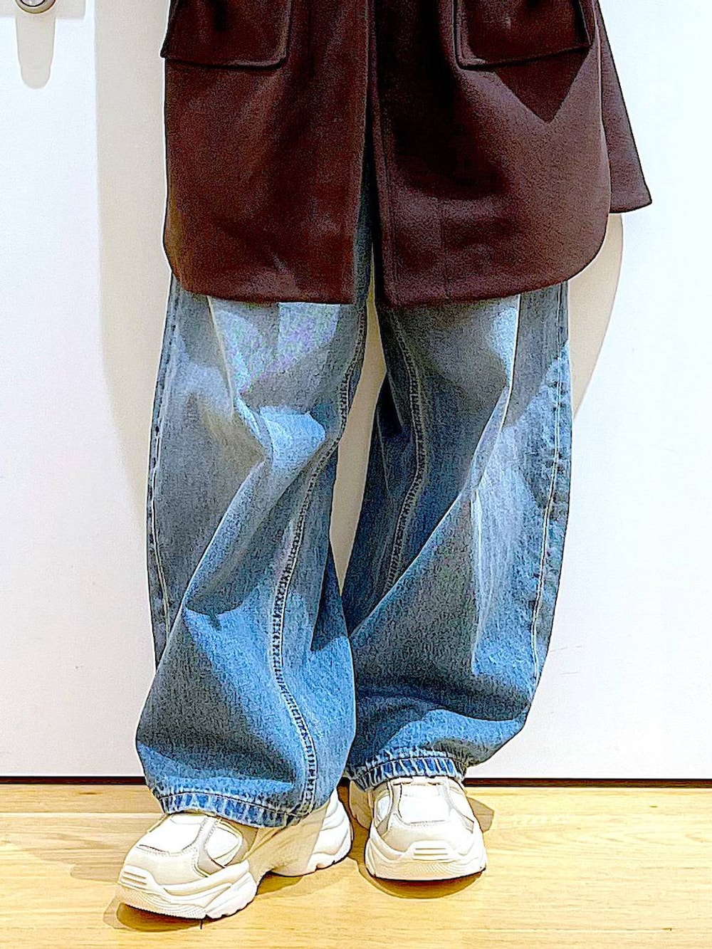 ブラウン系のその他アウター、ベージュ系のスニーカー、ブルー系のデニムパンツを着用したレディースの冬コーディネートの8枚目の写真