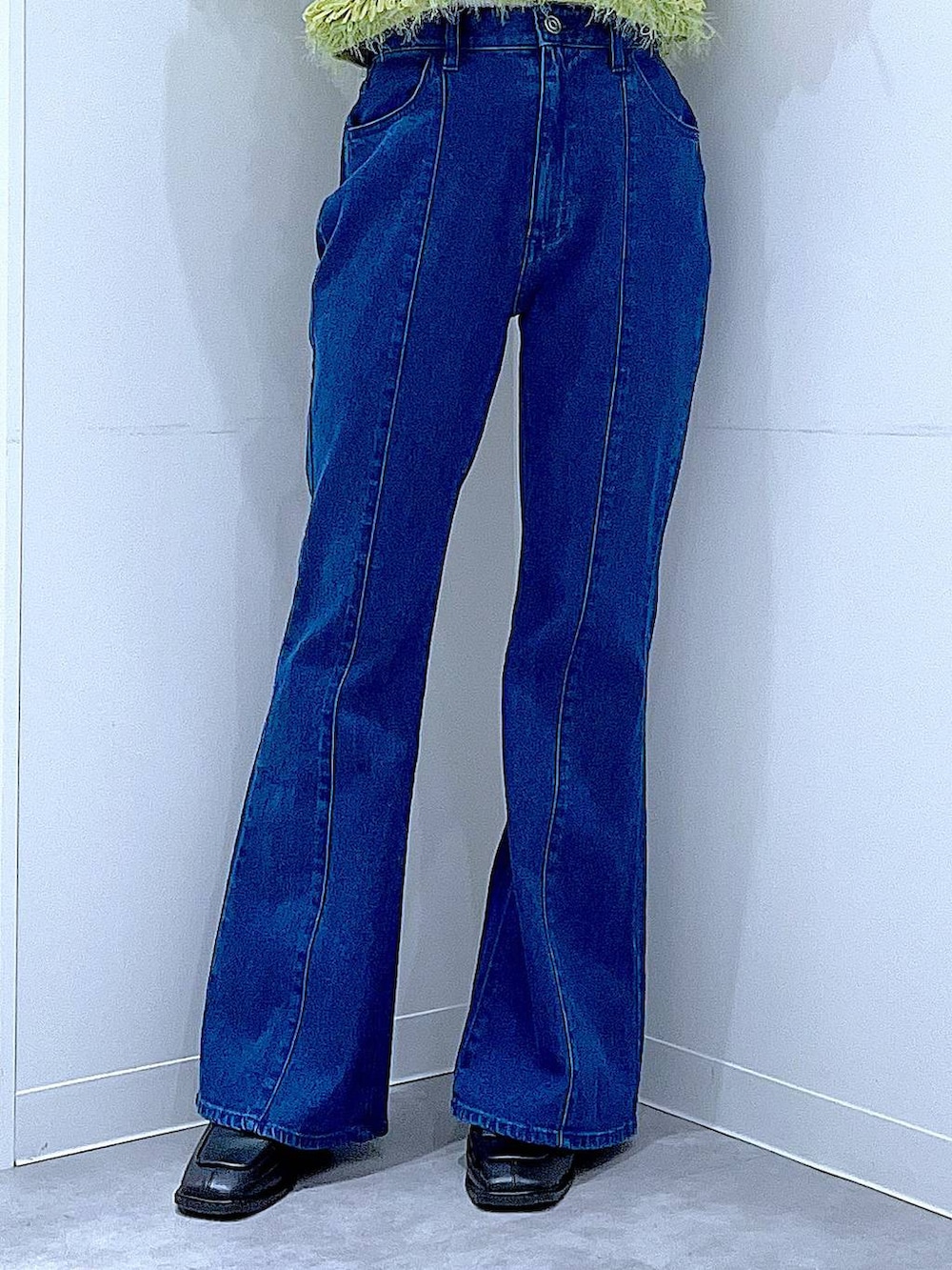 ブラック系のブーツ、ホワイト系のショルダーバッグ、グリーン系のベストを着用したレディースの春コーディネートの8枚目の写真