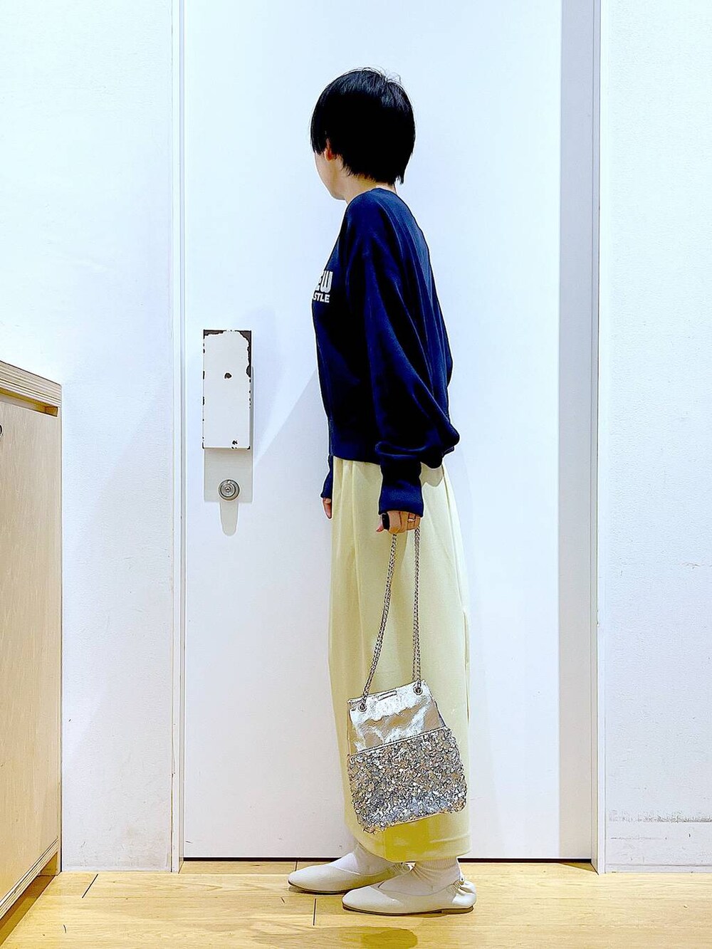 ホワイト系のパンプス、ブルー系のTシャツ/カットソー、イエロー系のスカートを着用したレディースの春コーディネートの3枚目の写真