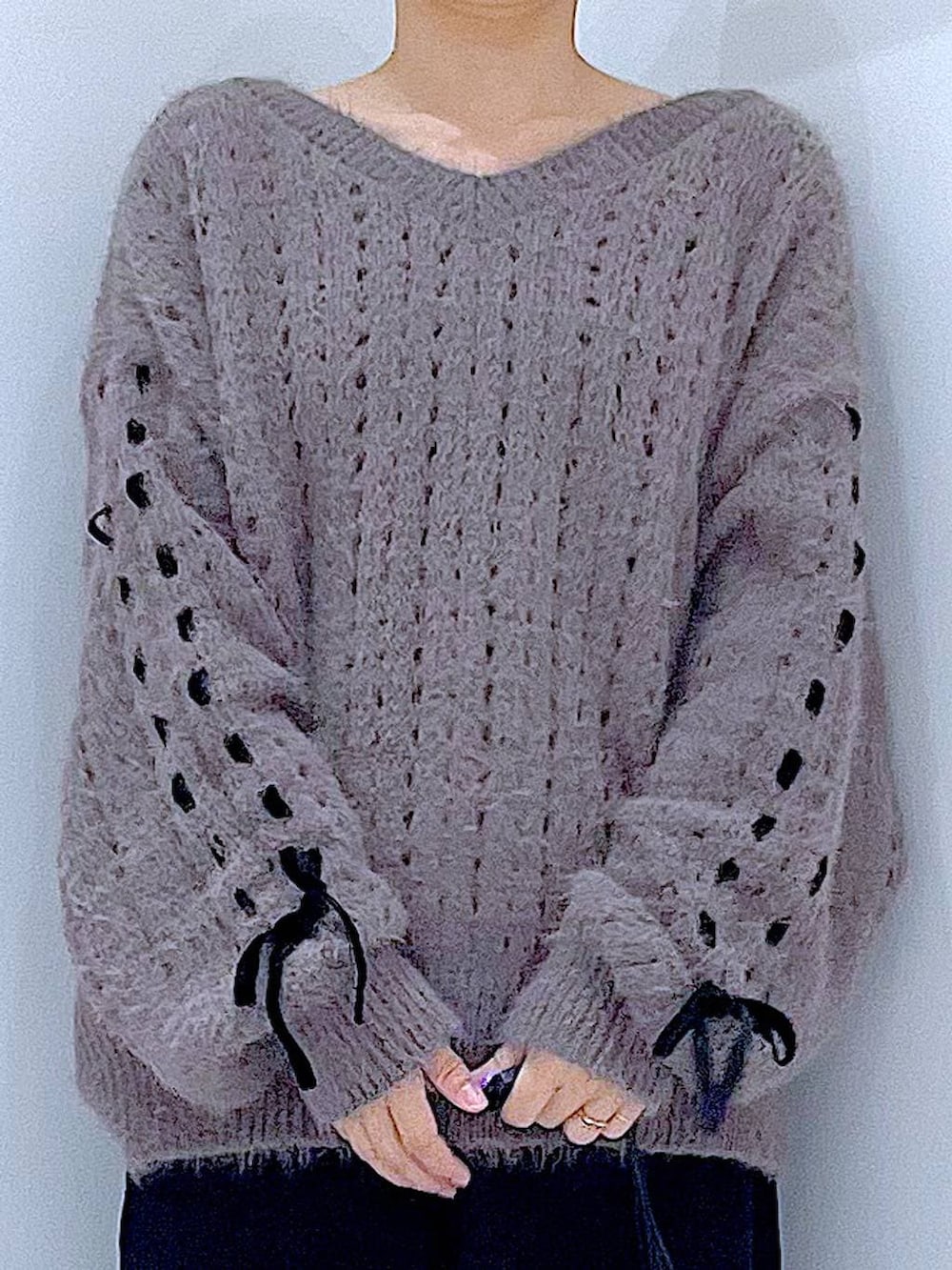 ブラック系のブーツ、ブラック系のショルダーバッグ、ベージュ系のニット/セーターを着用したレディースの冬コーディネートの7枚目の写真