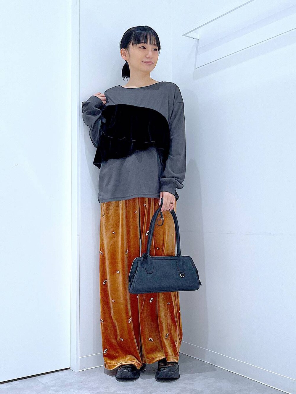 ブラック系のローファー、ブラック系のハンドバッグ、オレンジ系のその他パンツを着用したレディースの秋コーディネートの2枚目の写真