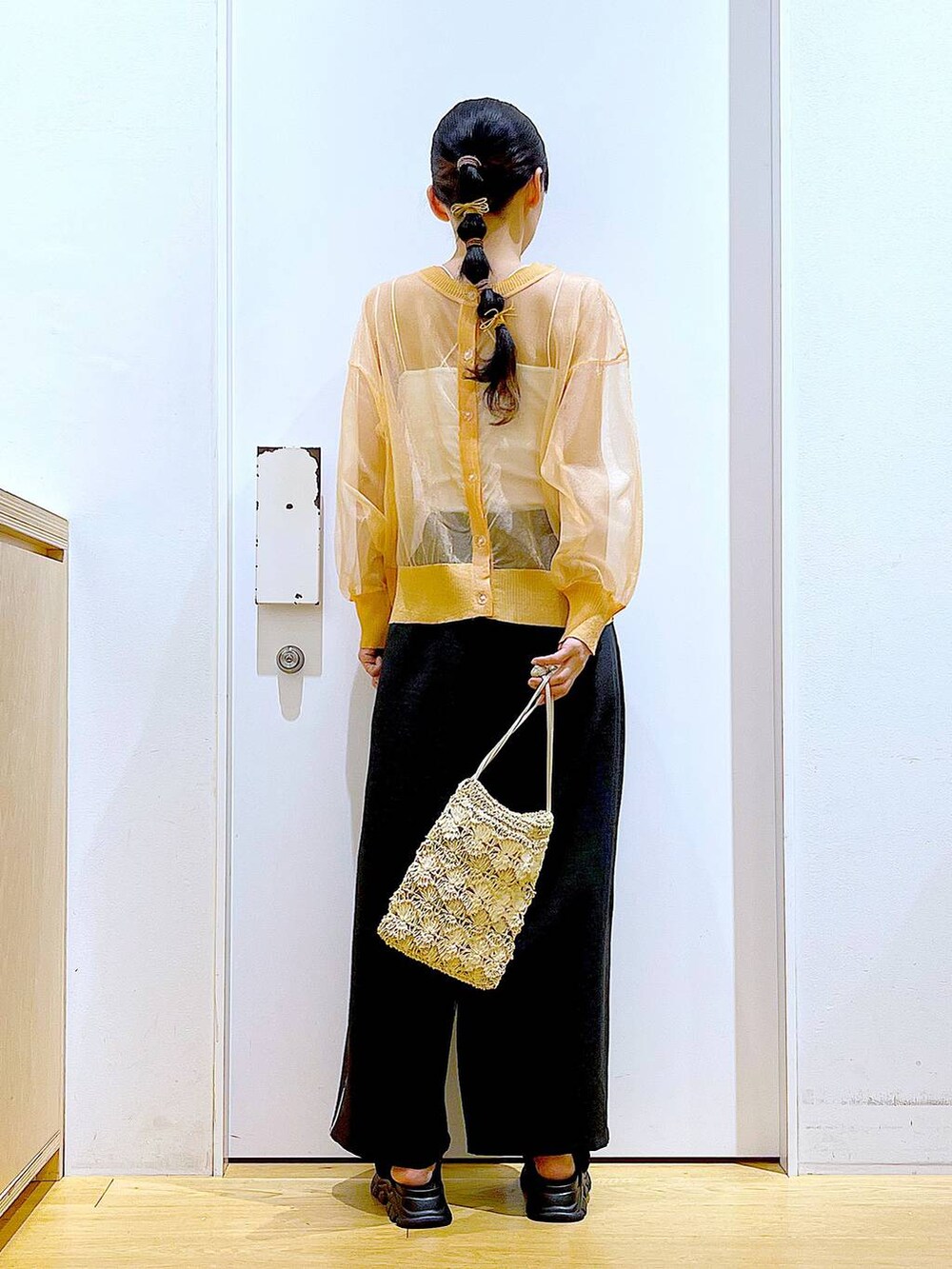 ブラック系のサンダル、オレンジ系のカーディガン/ボレロ、ベージュ系のショルダーバッグを着用したレディースの夏コーディネートの5枚目の写真