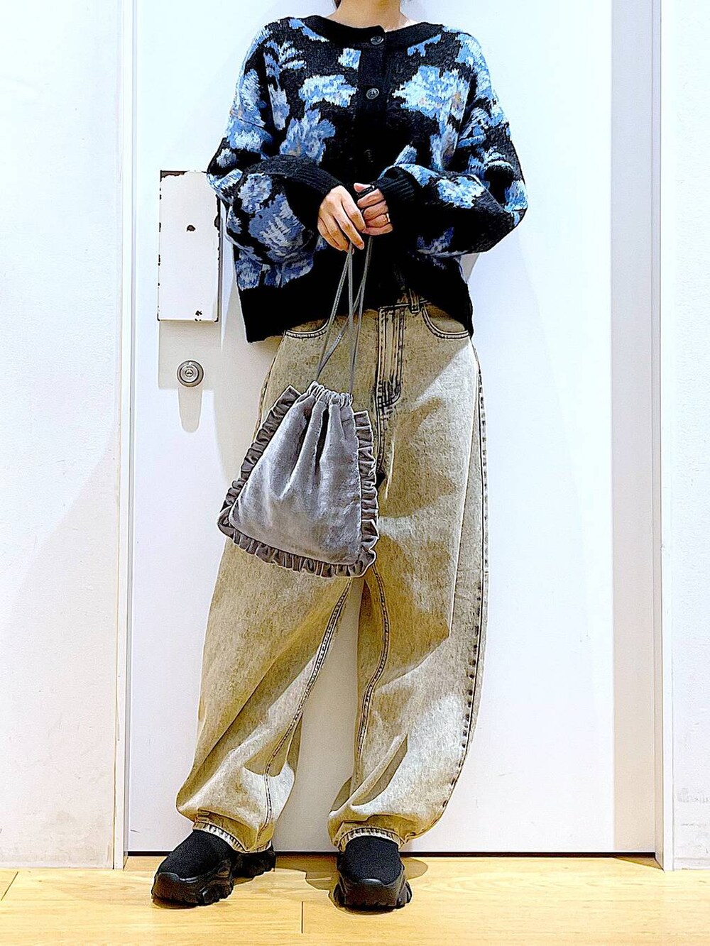 ブラック系のブーツ、グレー系のショルダーバッグ、ベージュ系のデニムパンツを着用したレディースの秋コーディネートの6枚目の写真