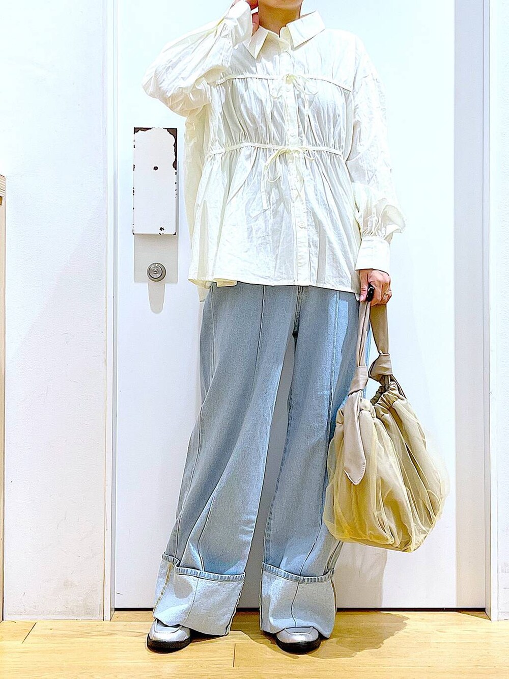 ベージュ系のトートバッグ、シルバー系のローファー、ホワイト系のシャツ/ブラウスを着用したレディースの秋コーディネートの6枚目の写真