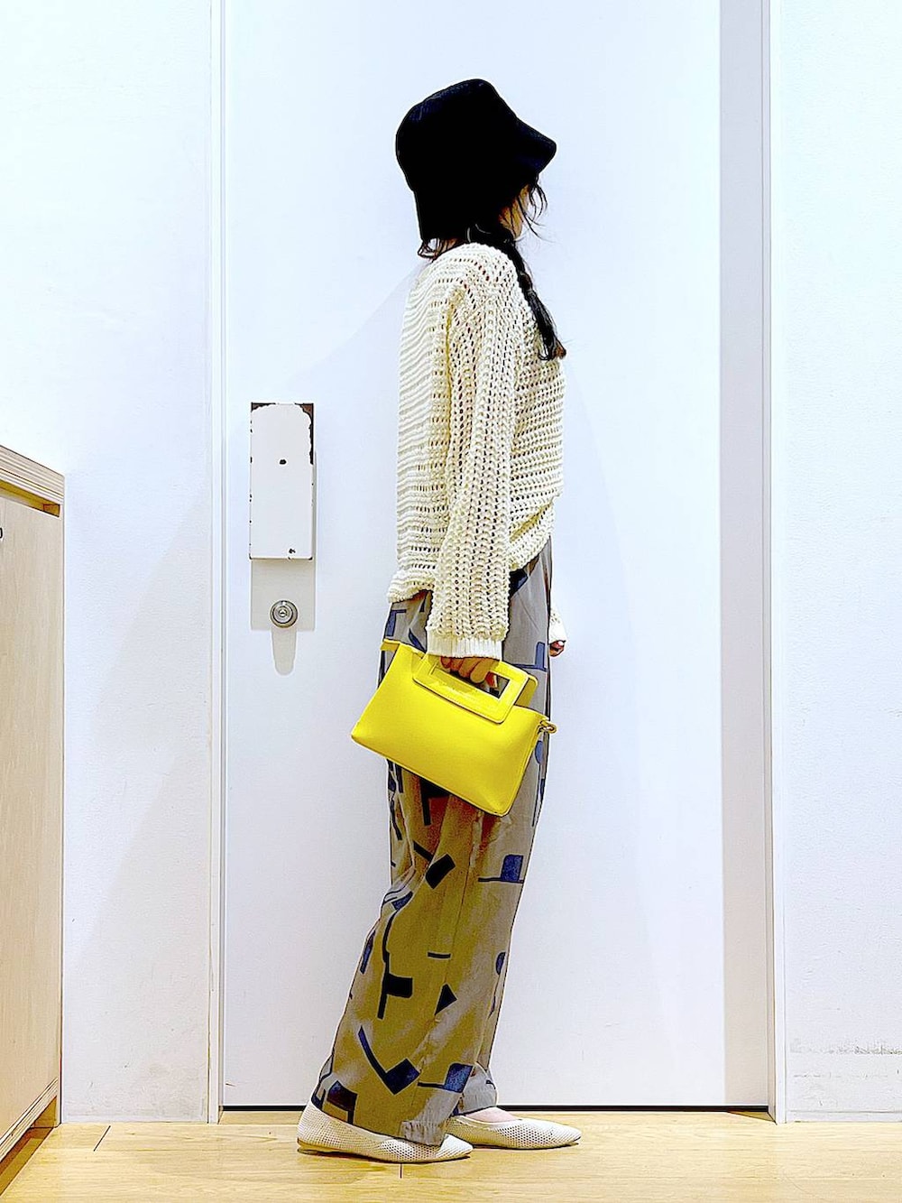 ホワイト系のニット/セーター、イエロー系のショルダーバッグ、ホワイト系のパンプスを着用したレディースの春コーディネートの4枚目の写真