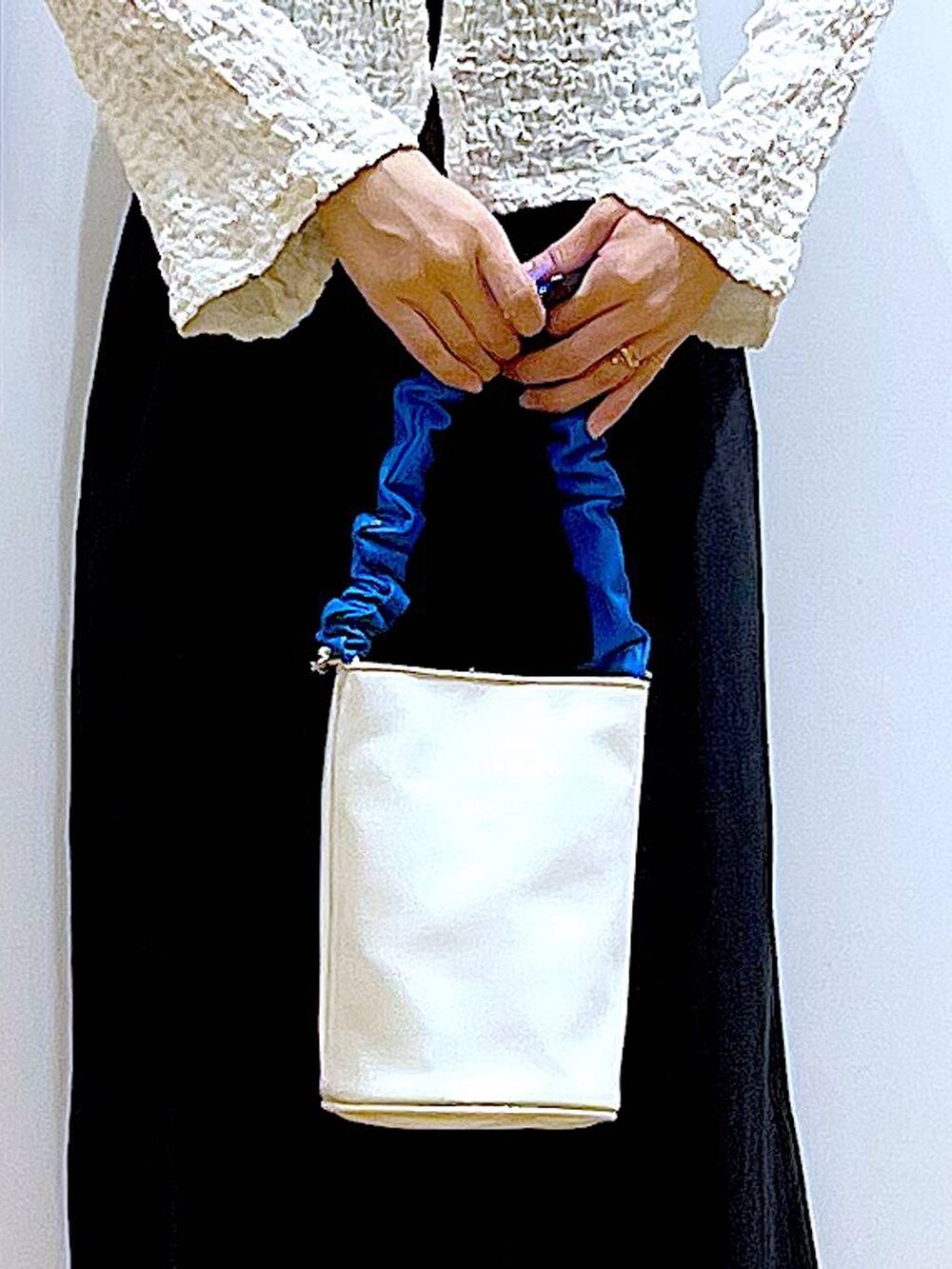 ブルー系のショルダーバッグ、ブラック系のパンプス、ブラック系のワンピースを着用したレディースの春コーディネートの9枚目の写真