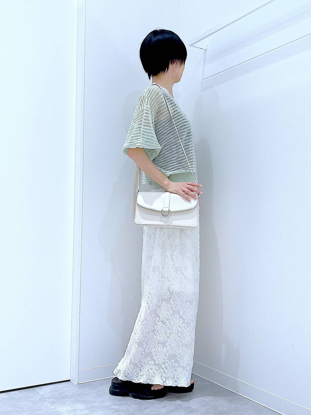 ブラック系のサンダル、ホワイト系のスカート、グリーン系のカーディガン/ボレロを着用したレディースの夏コーディネートの4枚目の写真