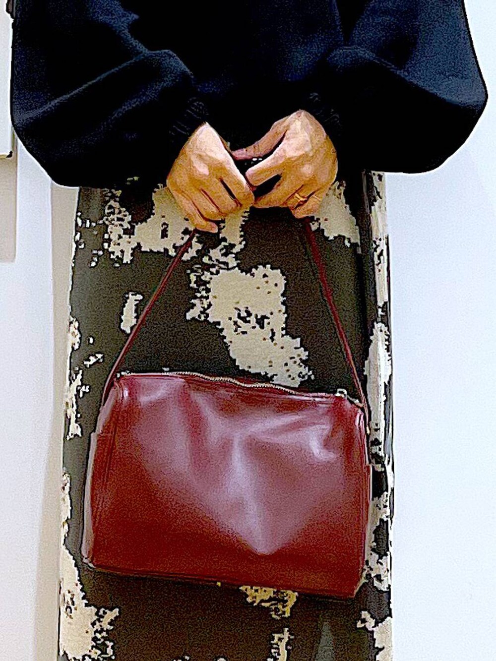 グレー系のスカート、レッド系のショルダーバッグ、ブラック系のブーツを着用したレディースの冬コーディネートの9枚目の写真