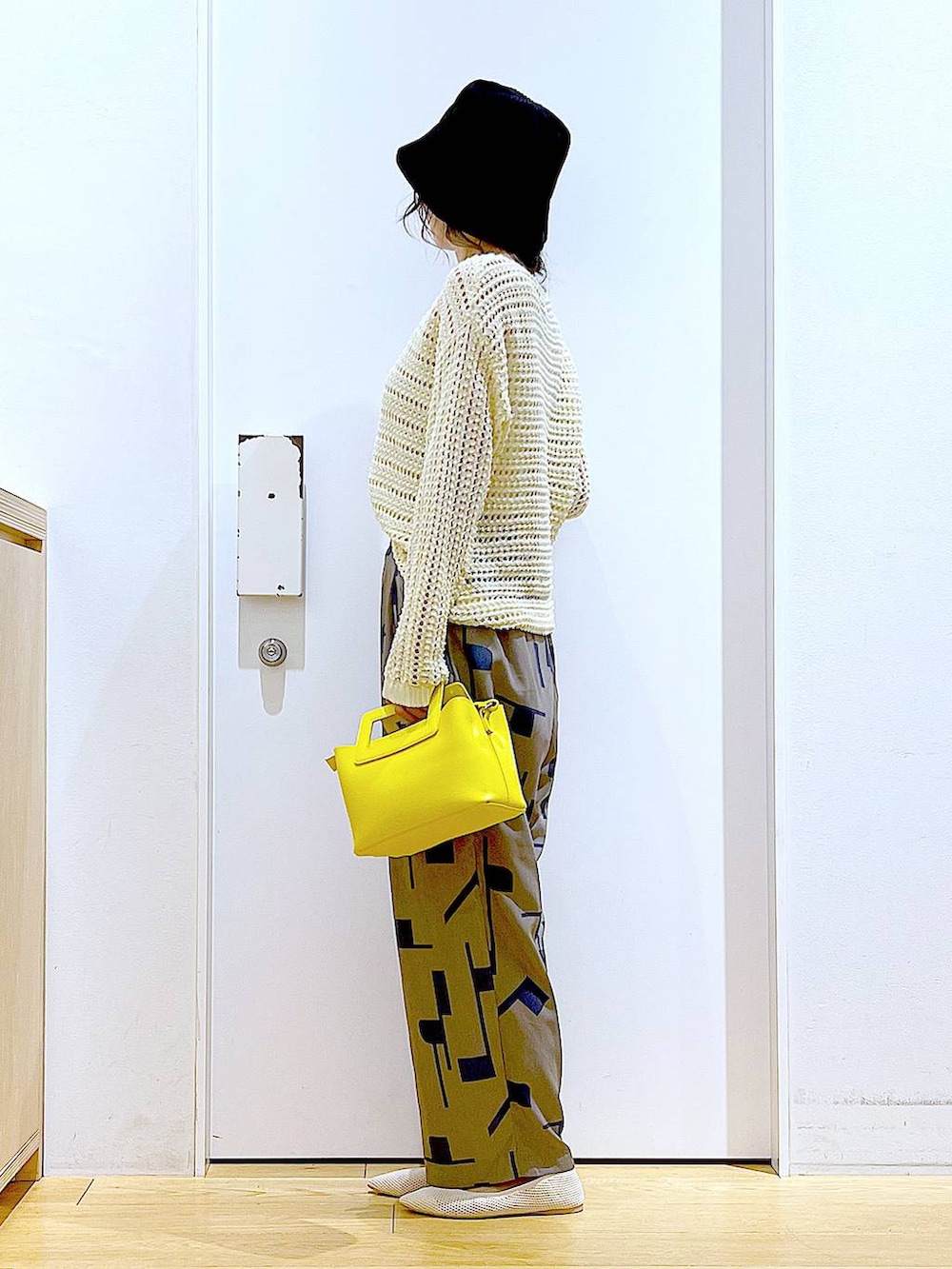 ホワイト系のニット/セーター、イエロー系のショルダーバッグ、ホワイト系のパンプスを着用したレディースの春コーディネートの3枚目の写真