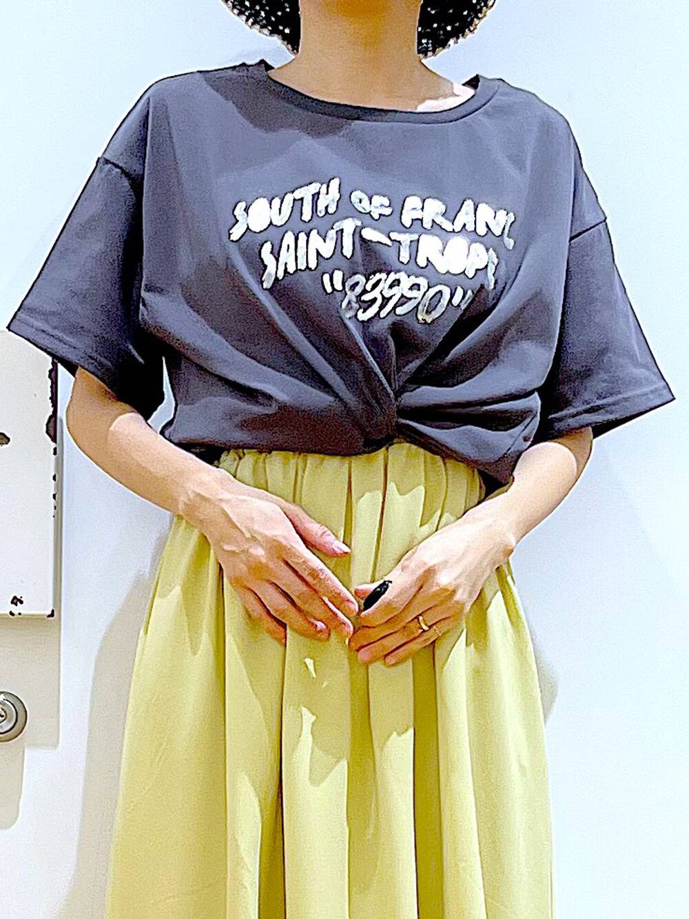 ブラック系のショルダーバッグ、ベージュ系のパンプス、イエロー系のワンピースを着用したレディースの春コーディネートの7枚目の写真