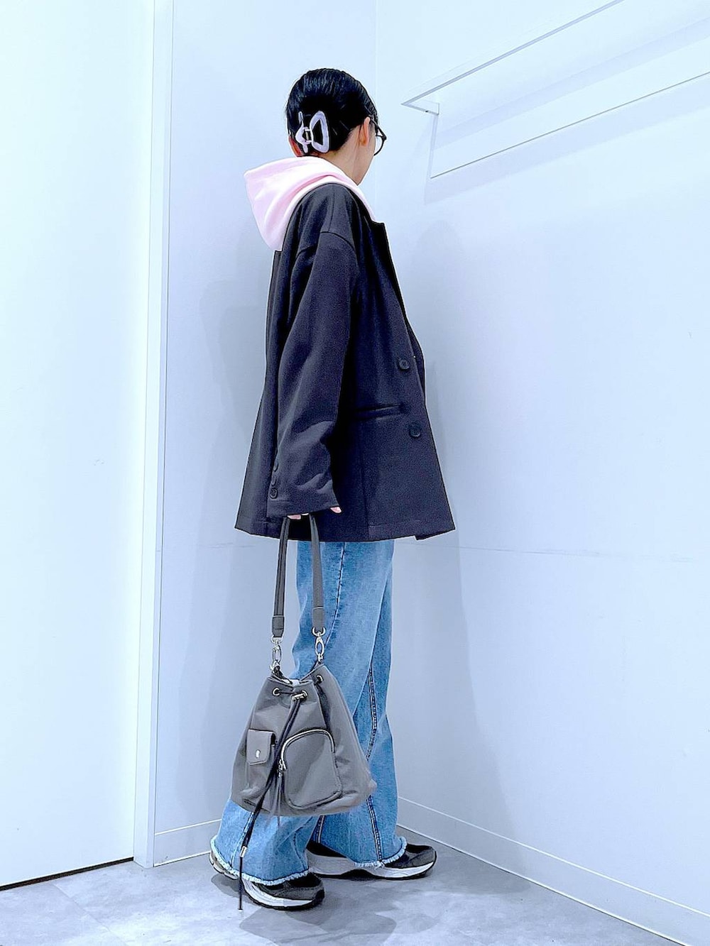 グレー系のテーラードジャケット、ブルー系のデニムパンツ、ピンク系のパーカーを着用したレディースの春コーディネートの4枚目の写真