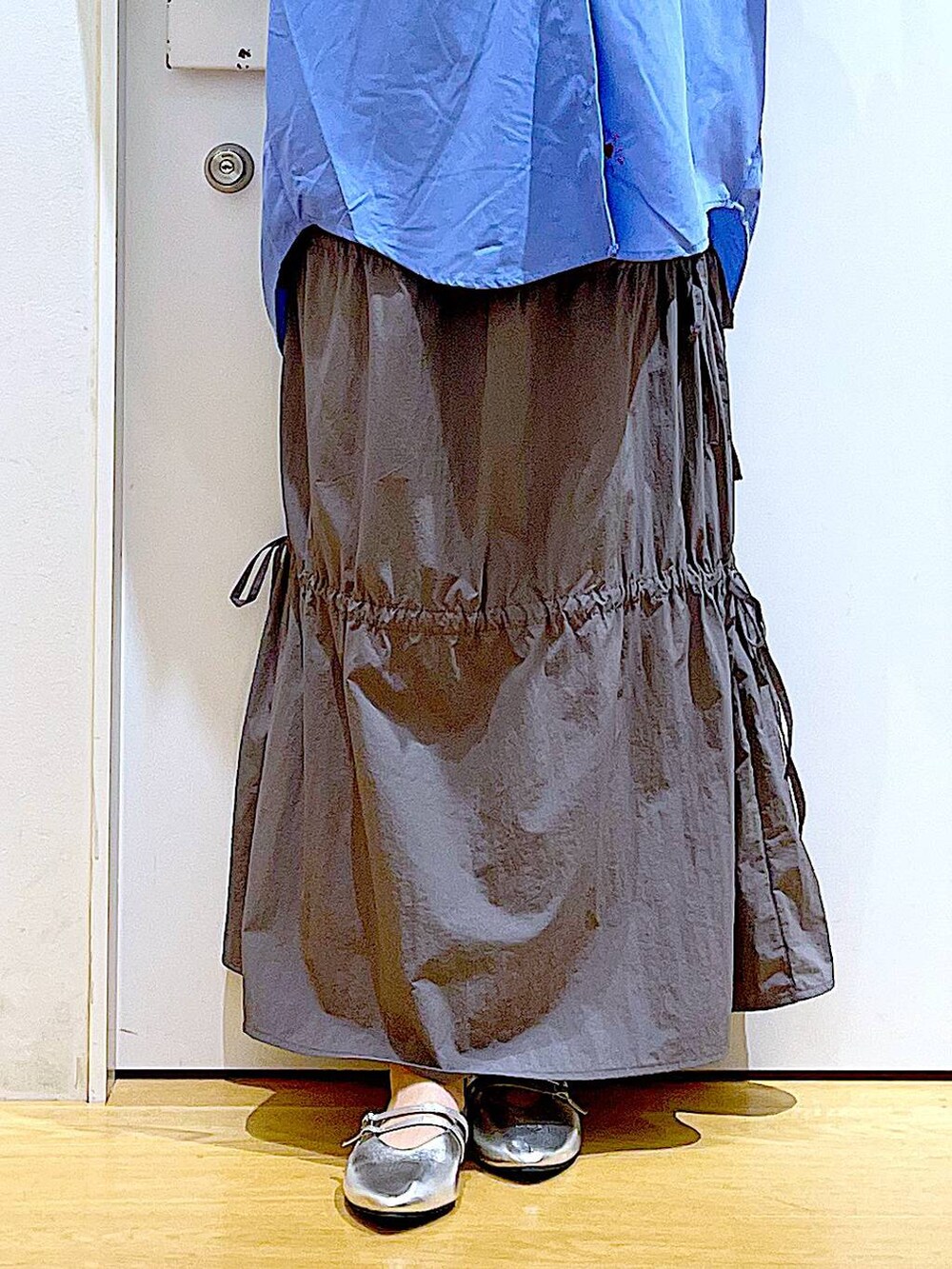 グレー系のショルダーバッグ、シルバー系のパンプス、グレー系のスカートを着用したレディースの秋コーディネートの8枚目の写真