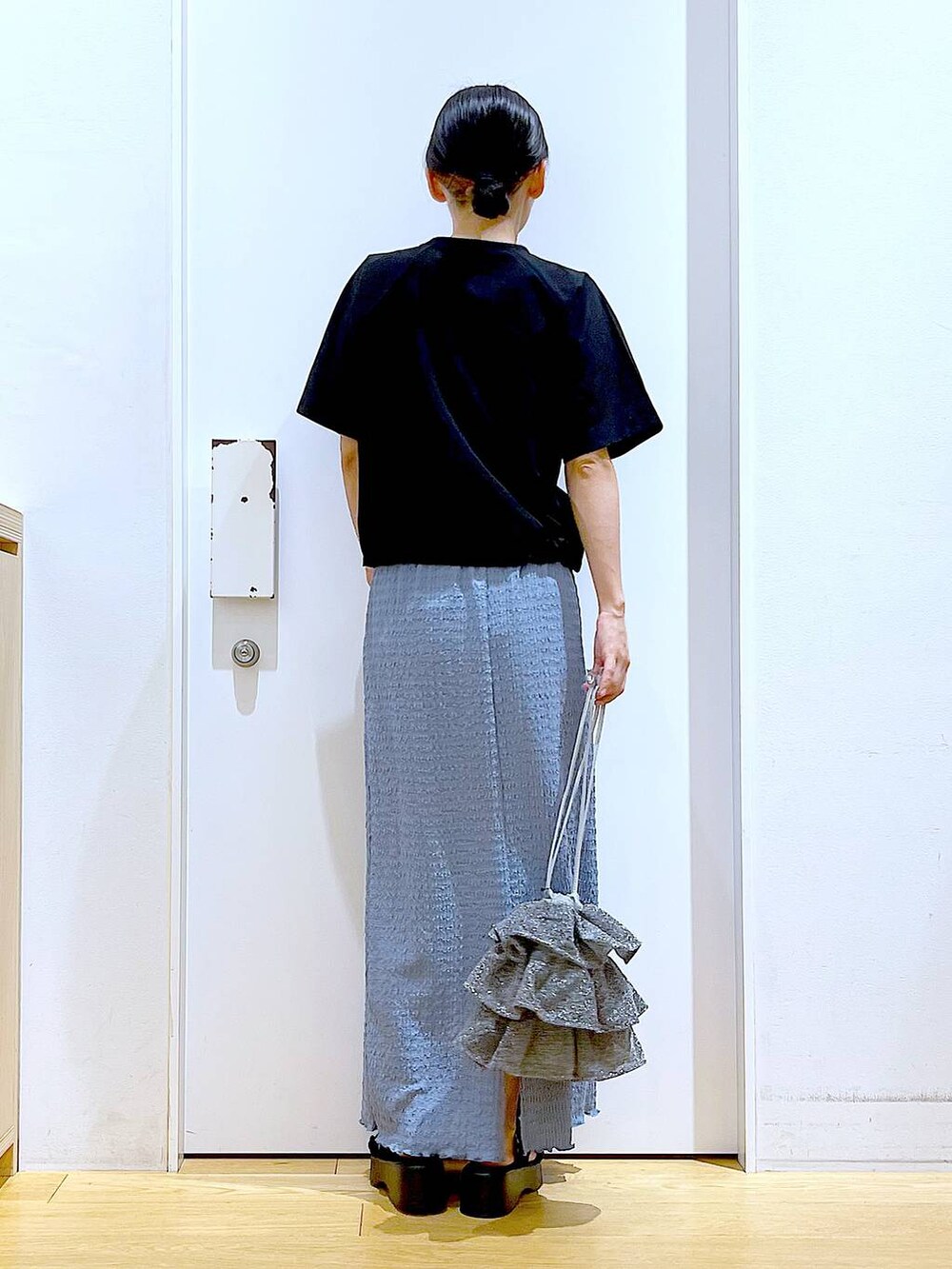 シルバー系のショルダーバッグ、ブルー系のスカート、ブラック系のTシャツ/カットソーを着用したレディースの夏コーディネートの5枚目の写真