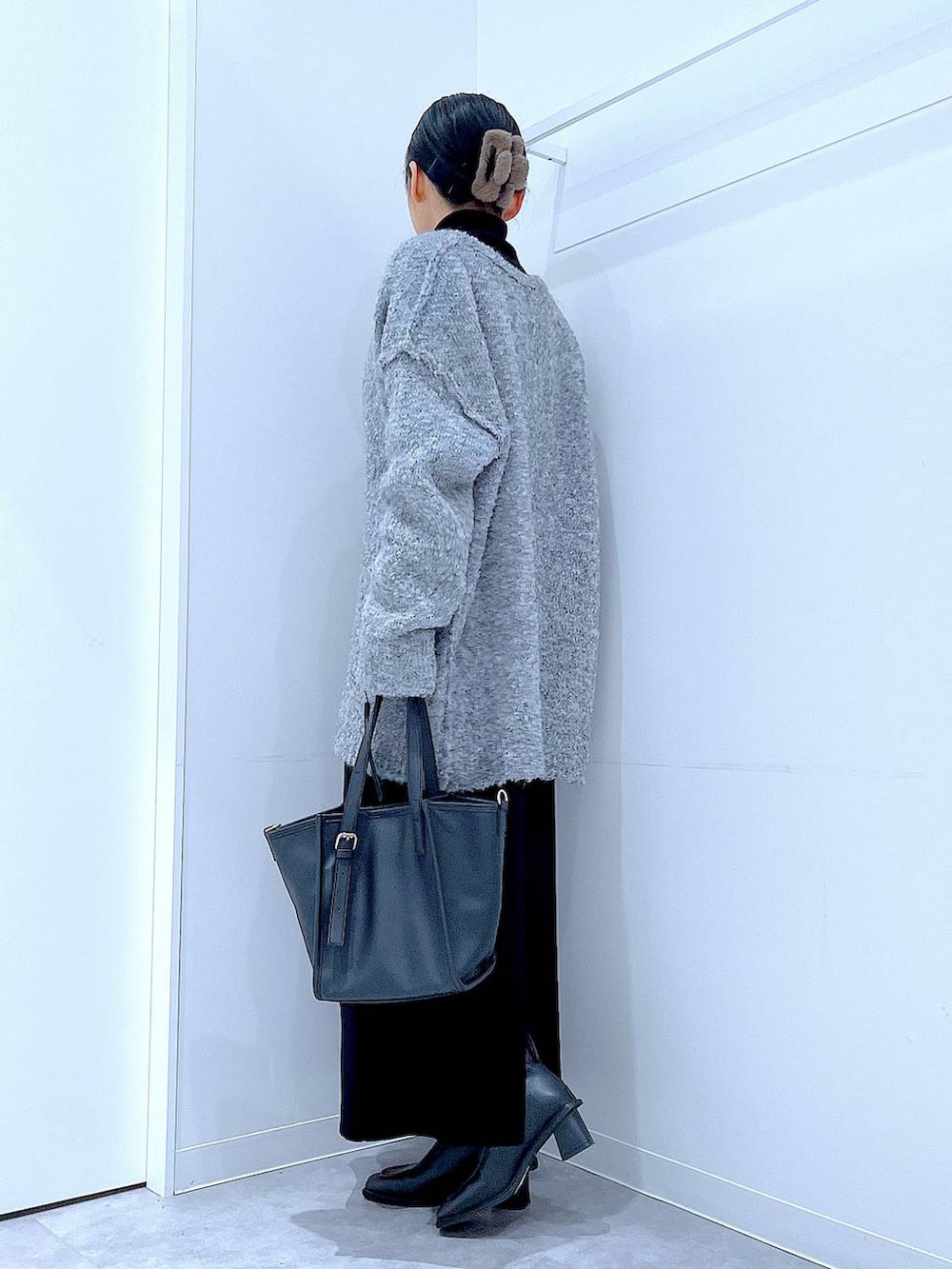 ブラック系のブーツ、グレー系のニット/セーター、ブラック系のスカートを着用したレディースの冬コーディネートの3枚目の写真