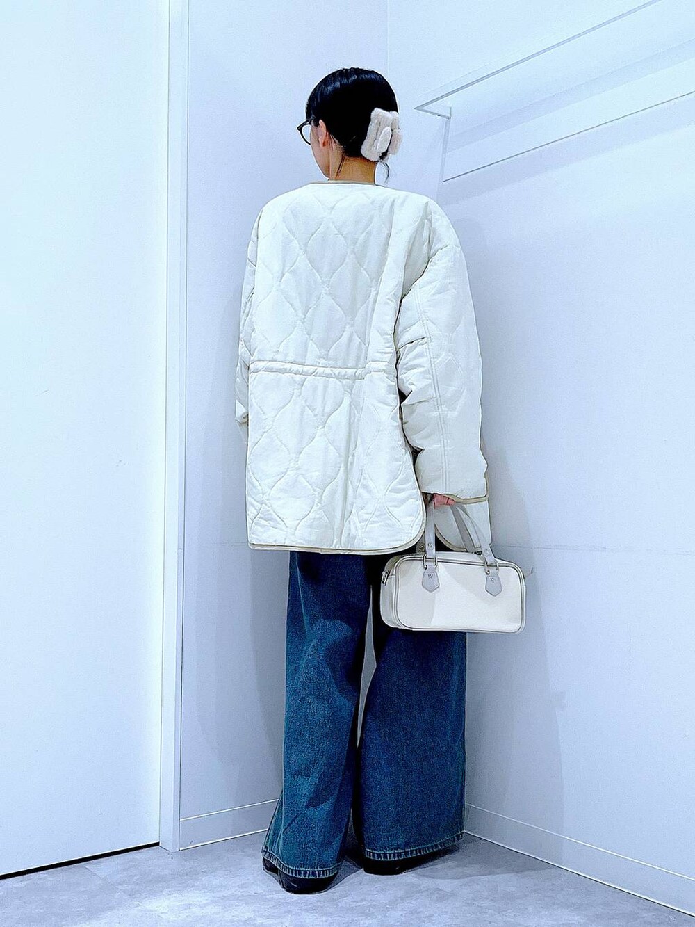 ベージュ系のブルゾン、ブラック系のブーツ、ブルー系のデニムパンツを着用したレディースの冬コーディネートの5枚目の写真